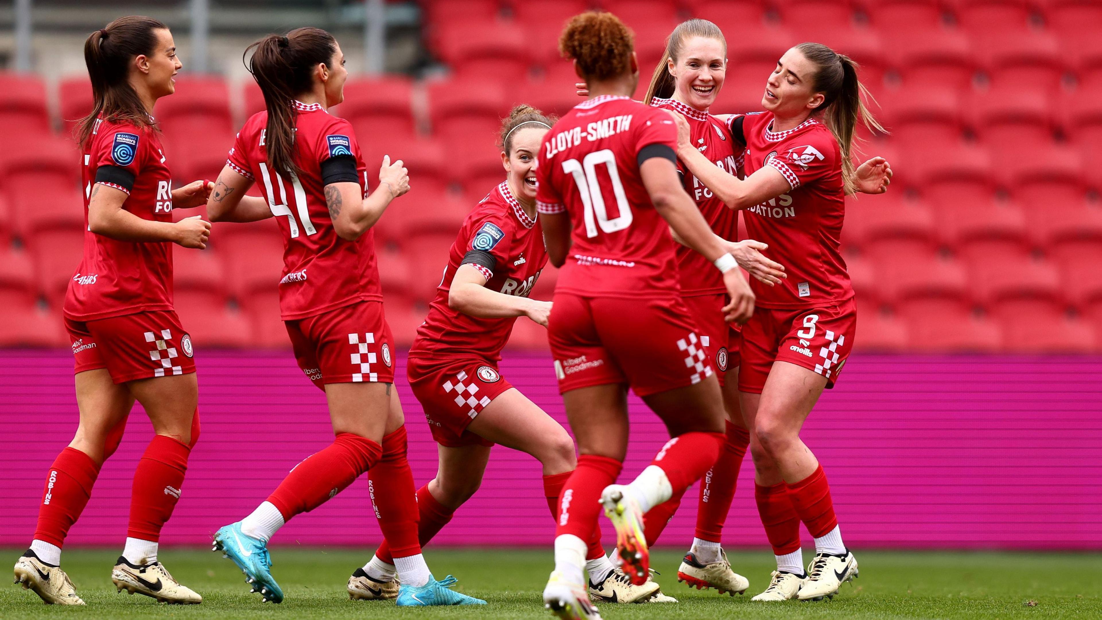 Six different players from Bristol City Women's FC, all in red kits, celebrate a goal scored against Charlton Athletic at Ashton Gate