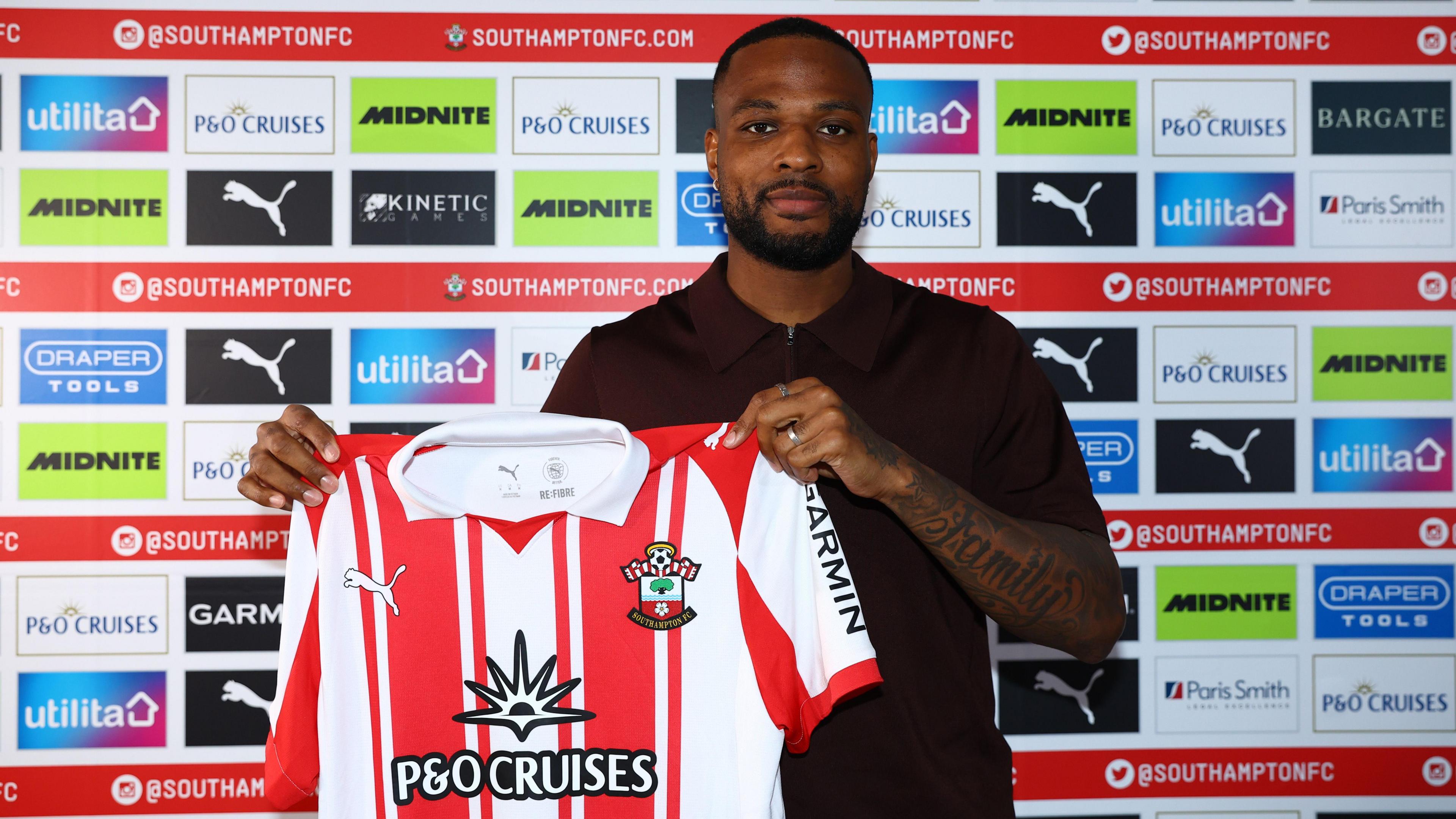 Cyle Larin poses for a photo with the Southampton shirt after signing for the club