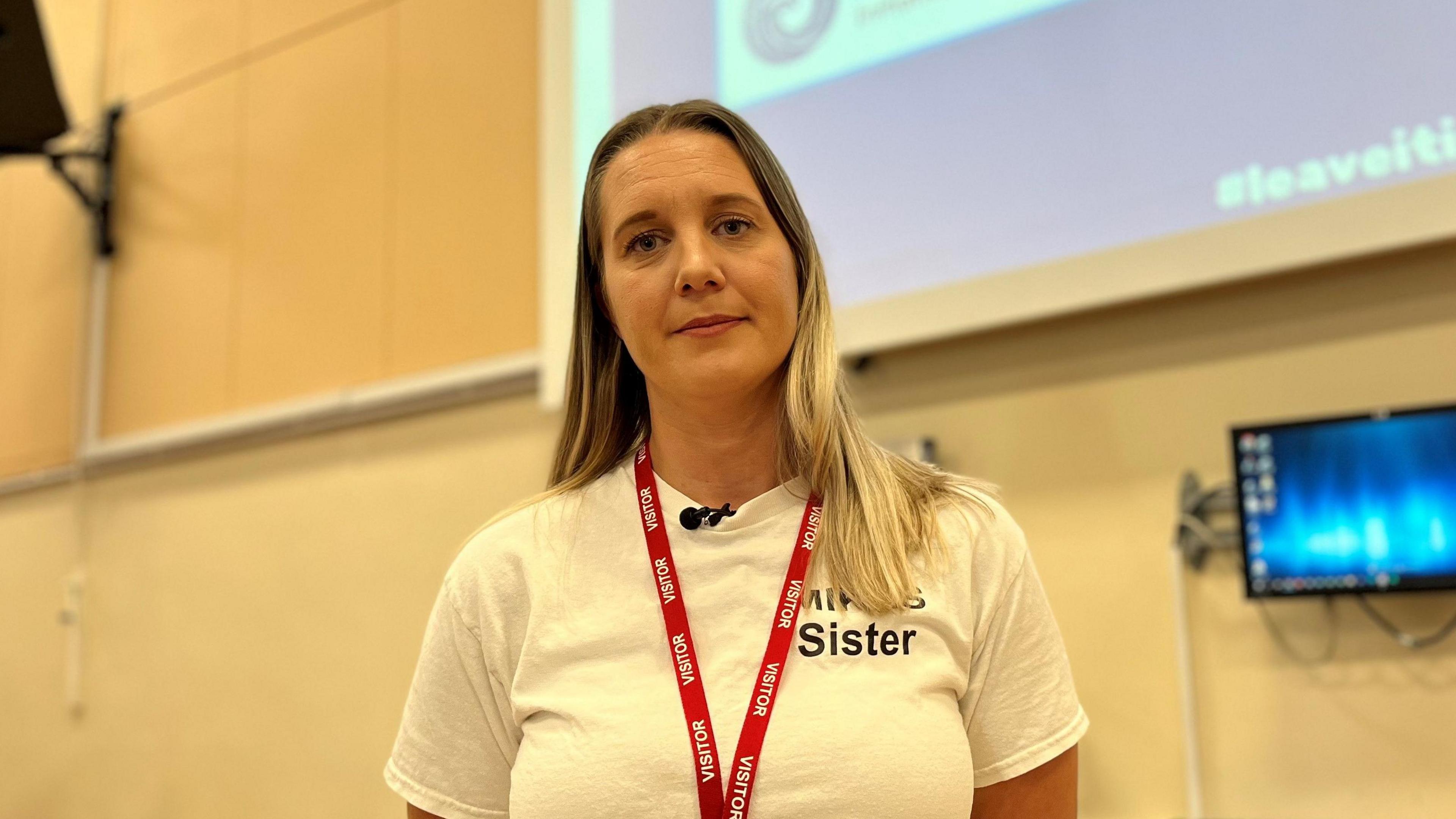 Becky Dustan delivering a knife crime talk at a school in Cornwall, wearing a top that says Mike's sister slightly obscured by her hair