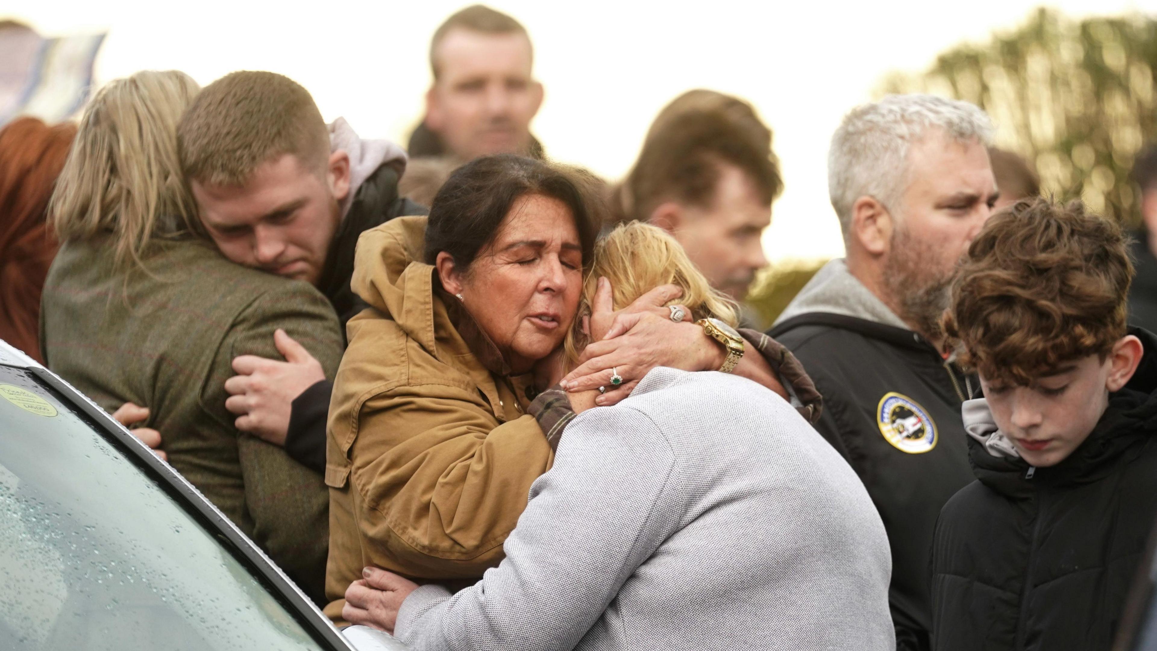 Women embrace at a vigil held for the Creeslough victims