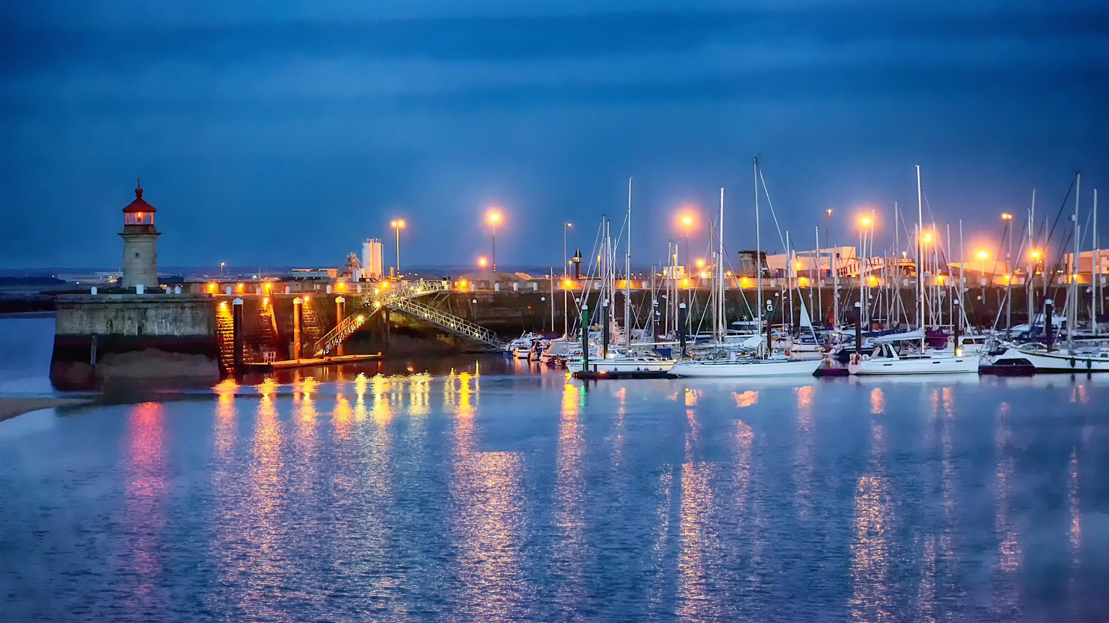 Ramsgate Royal Harbour lit up at dusk.