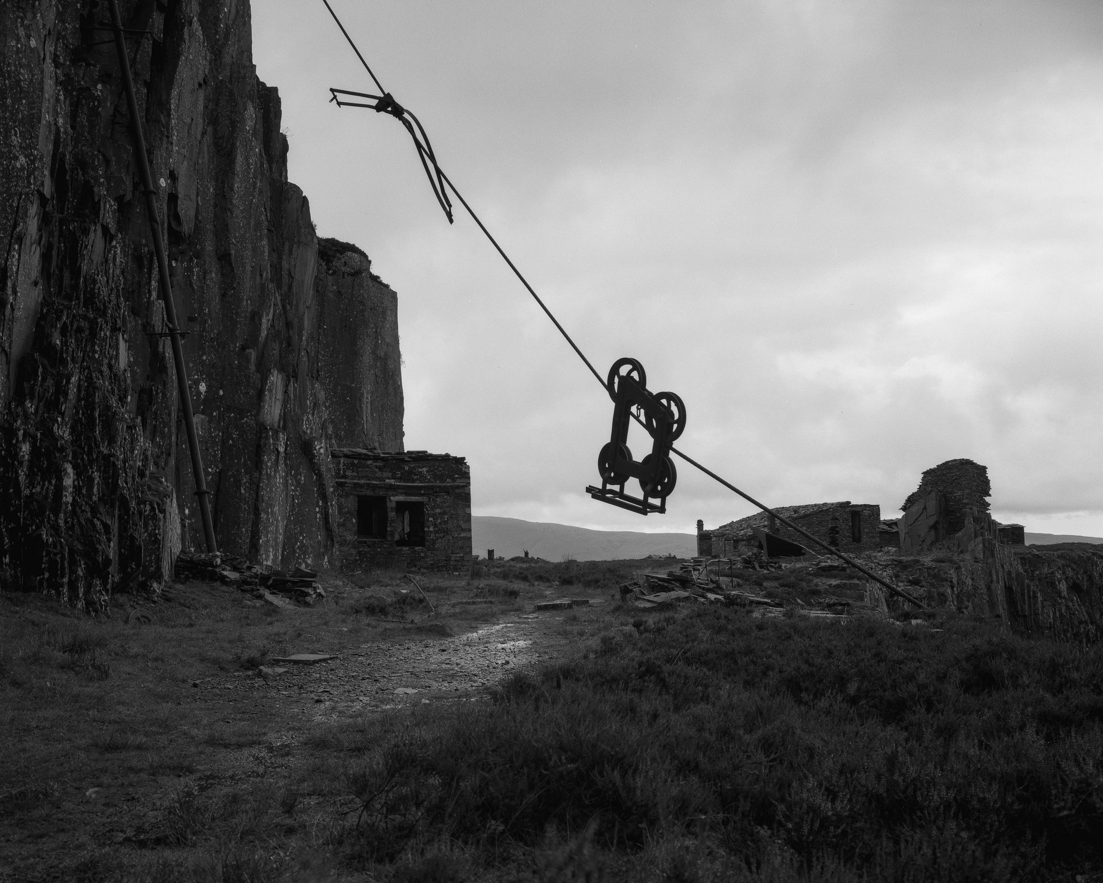 Kyle's black and white photograph of metal machinery hanging from a rope on a craggy slate hillside