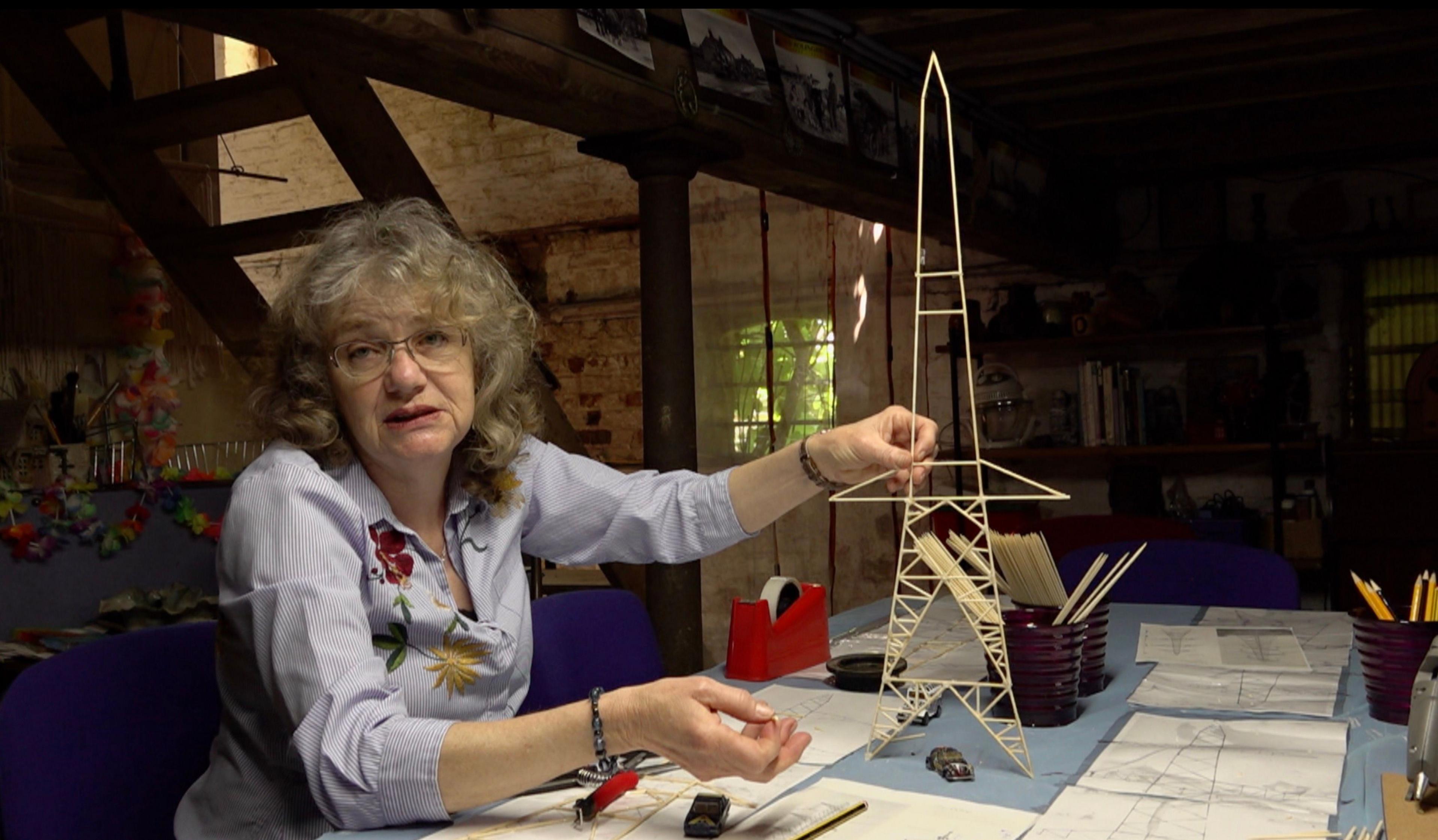 Nicola Hughes touching a model of a pylon with her left hand