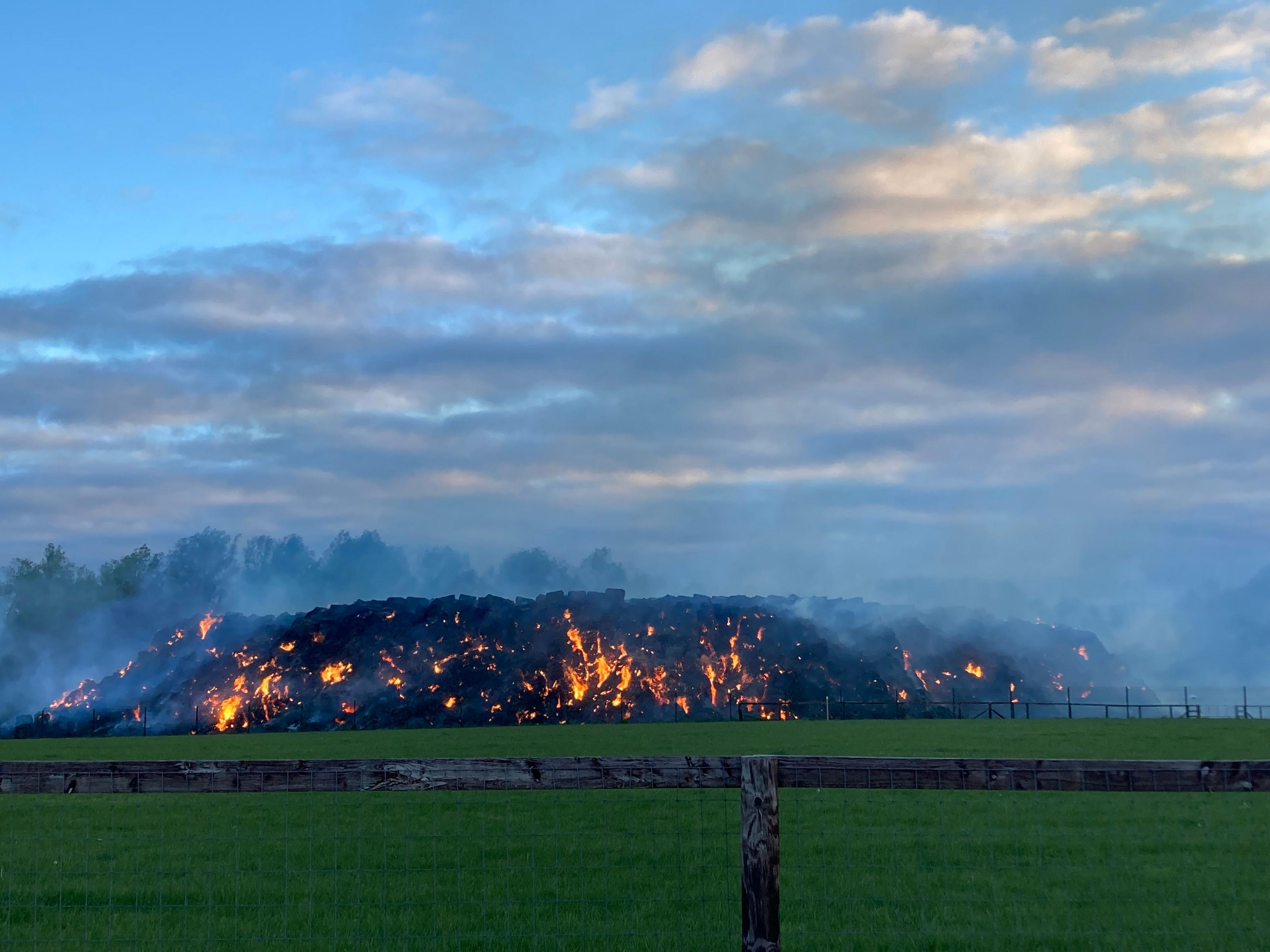 Stack of straw on fire in daylight