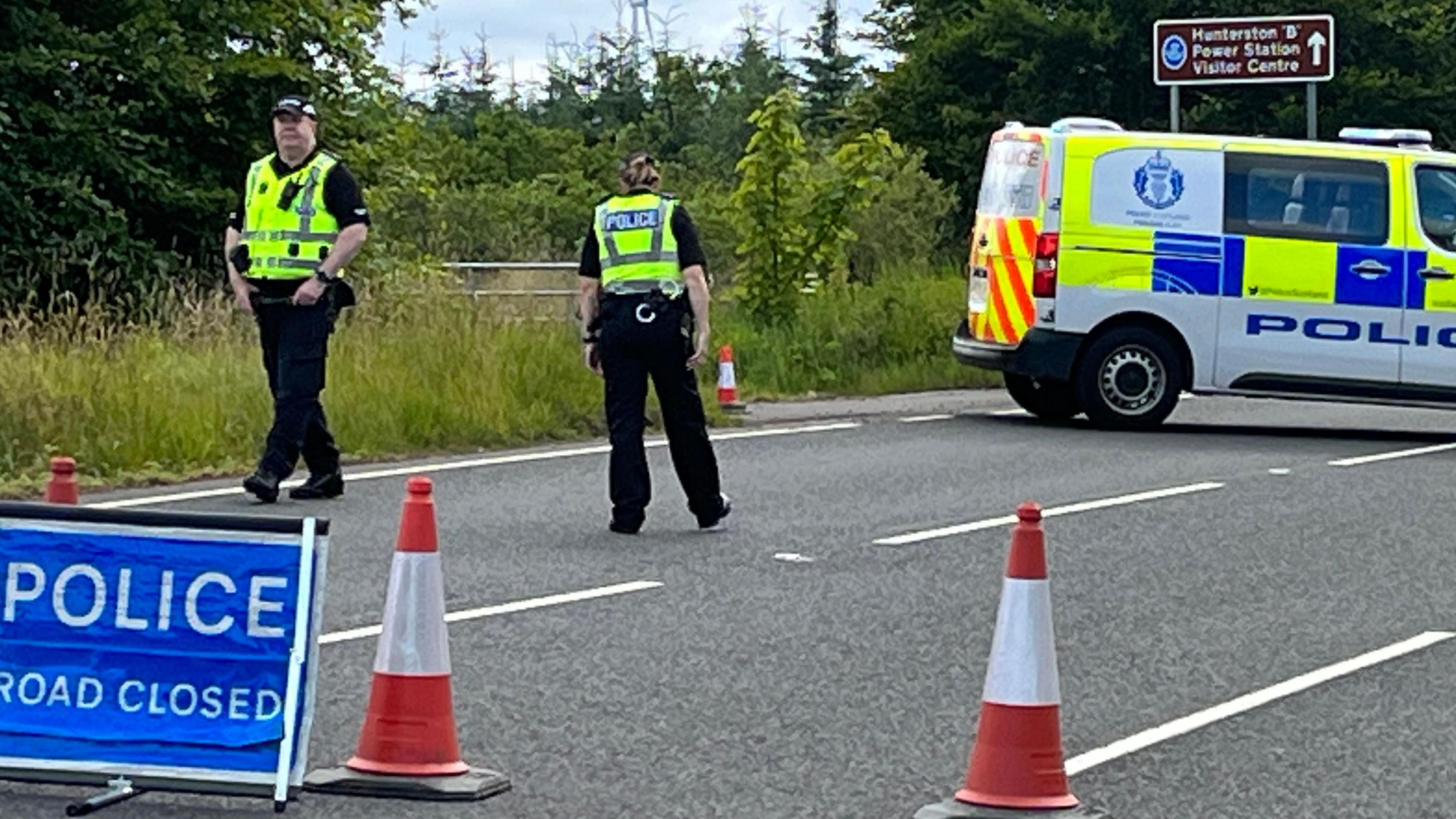 Two police officers standing infront of a road closed sign on the A760 near Largs