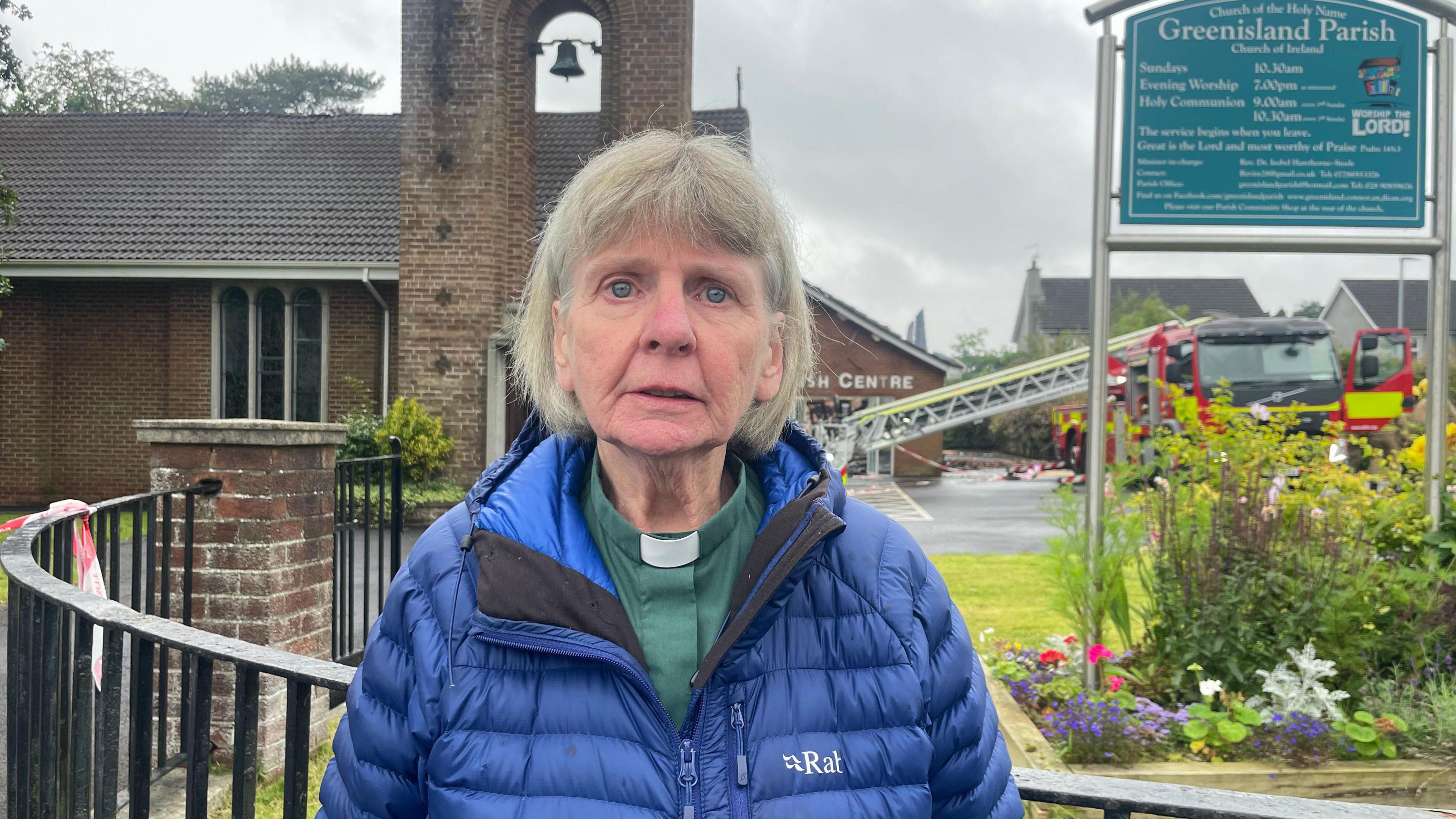 Rev Dr Izzy Hawthorne-Steele with the church in the background