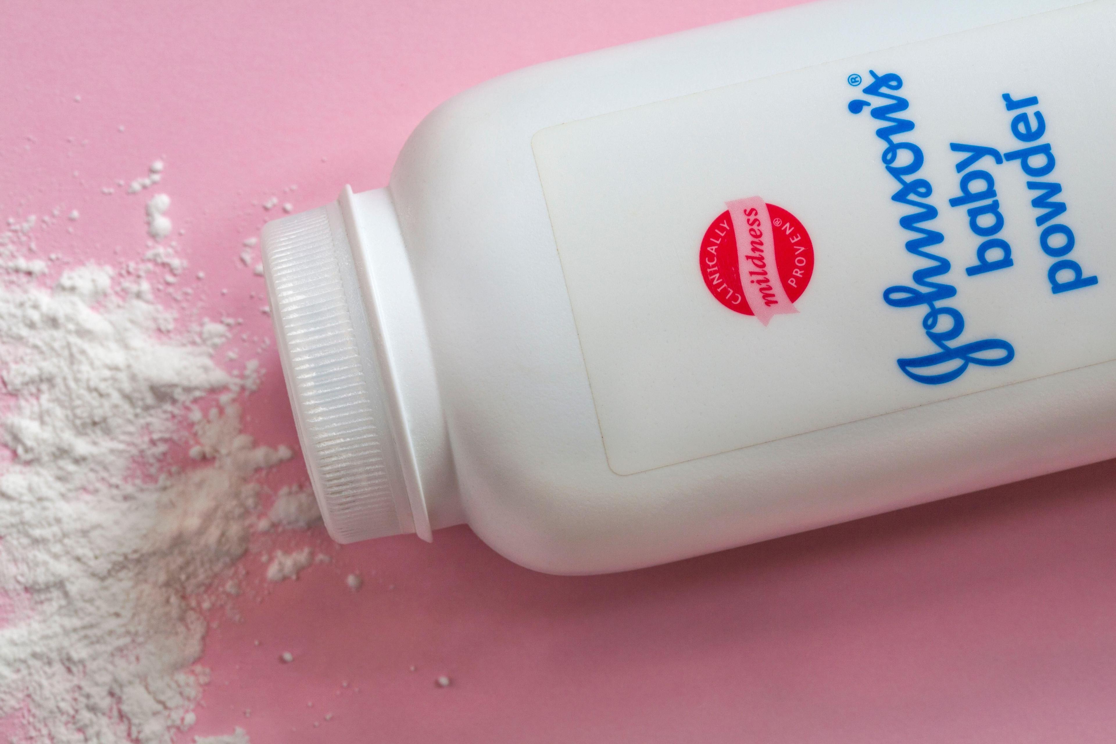 Johnson's baby powder - Johnson & Johnson baby powder with contents spilled set on pink background