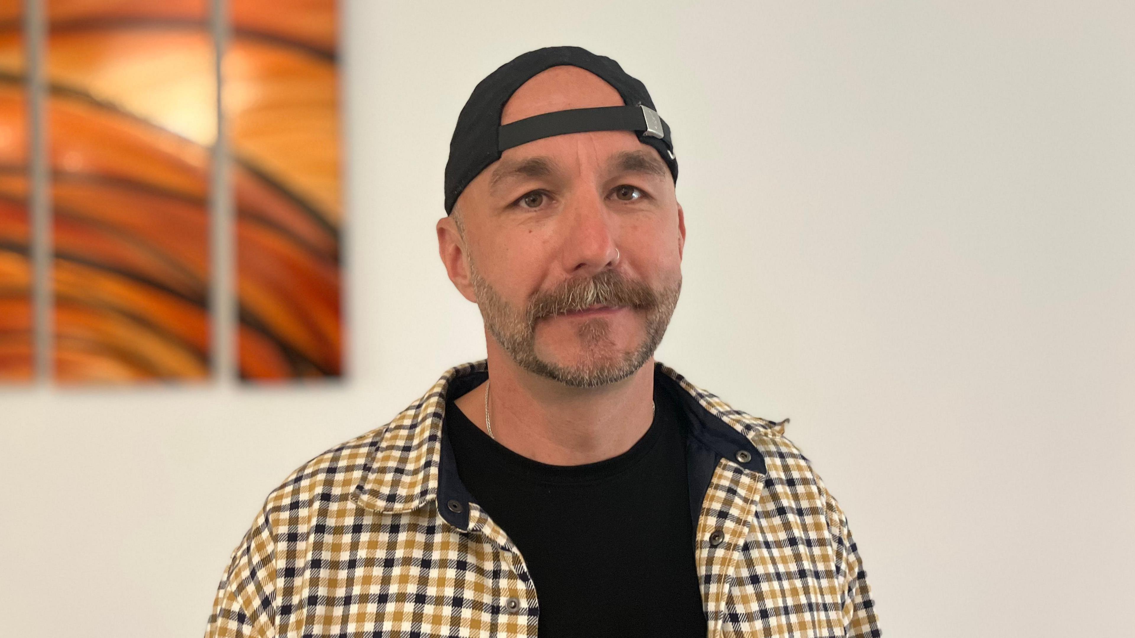 Paul Gribby stood in front of a cream background