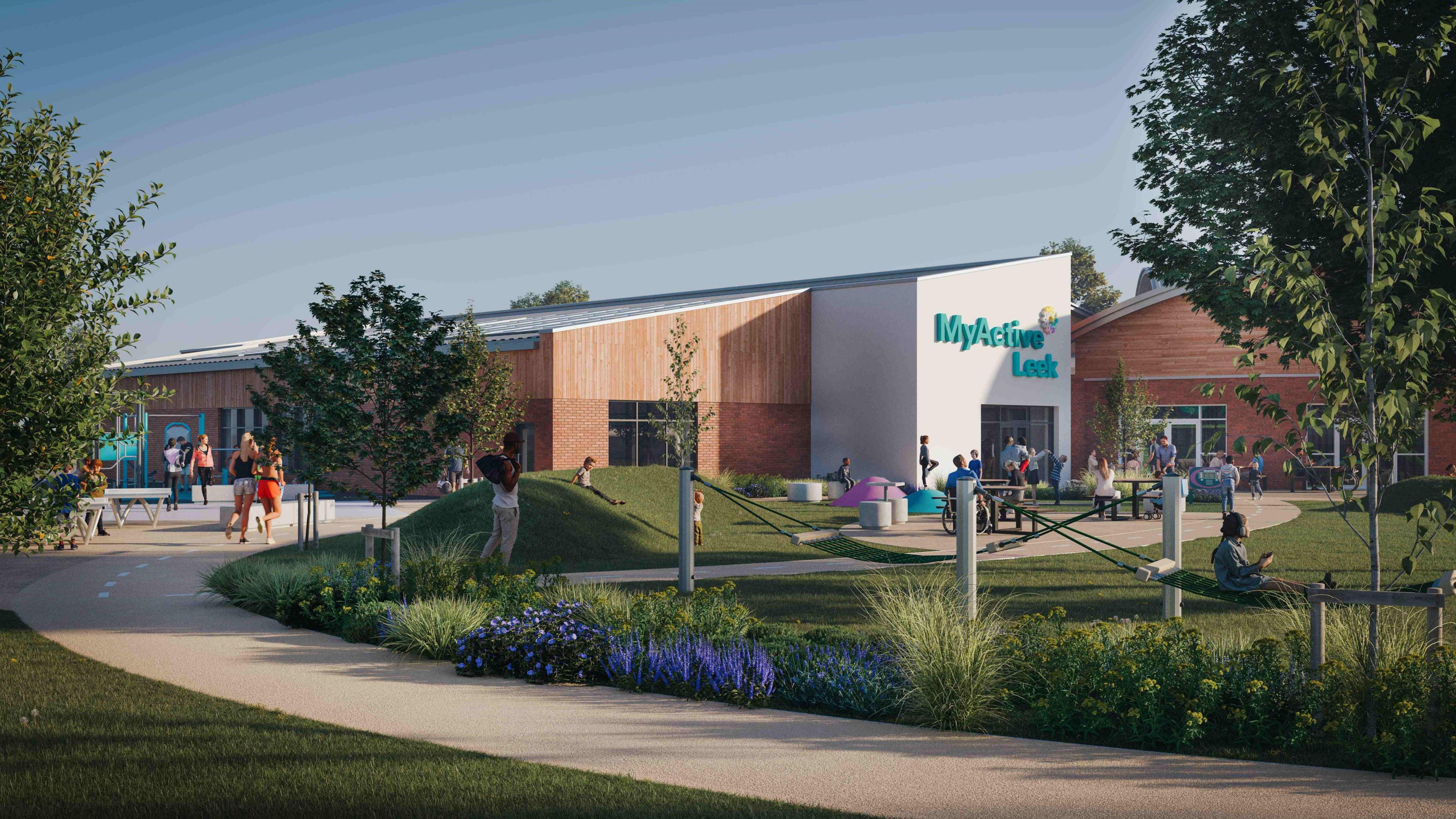An artist's impression of a new leisure centre viewed from ground level. There is a landscaped footpath leading to a large white-painted entrance to the building. The main section of the building is clad with wood in its top half. There are people sitting at picnic benches and walking around a garden area in front of the building.