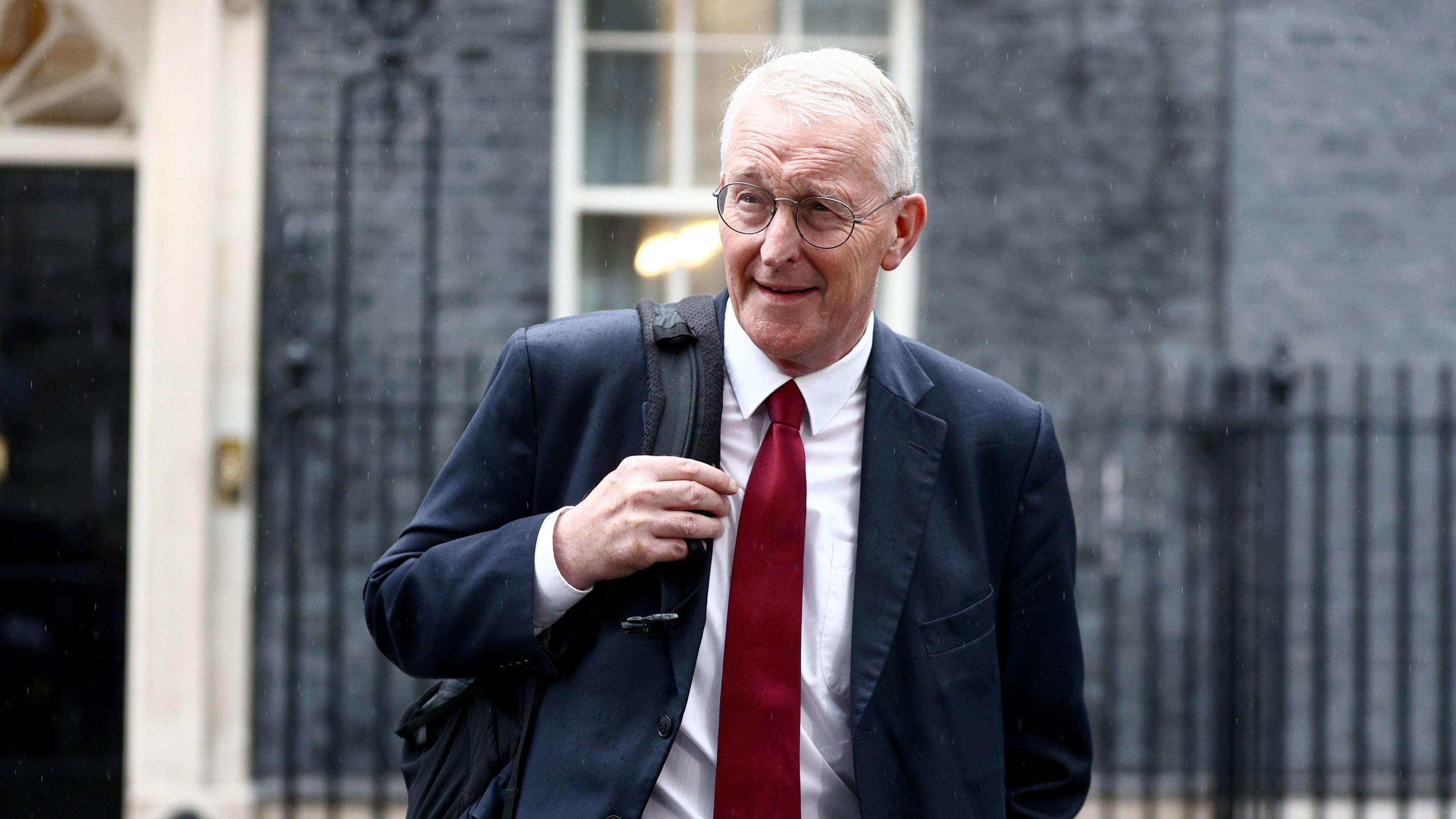 Hilary Benn pictured wearing a dark red tie and navy blu