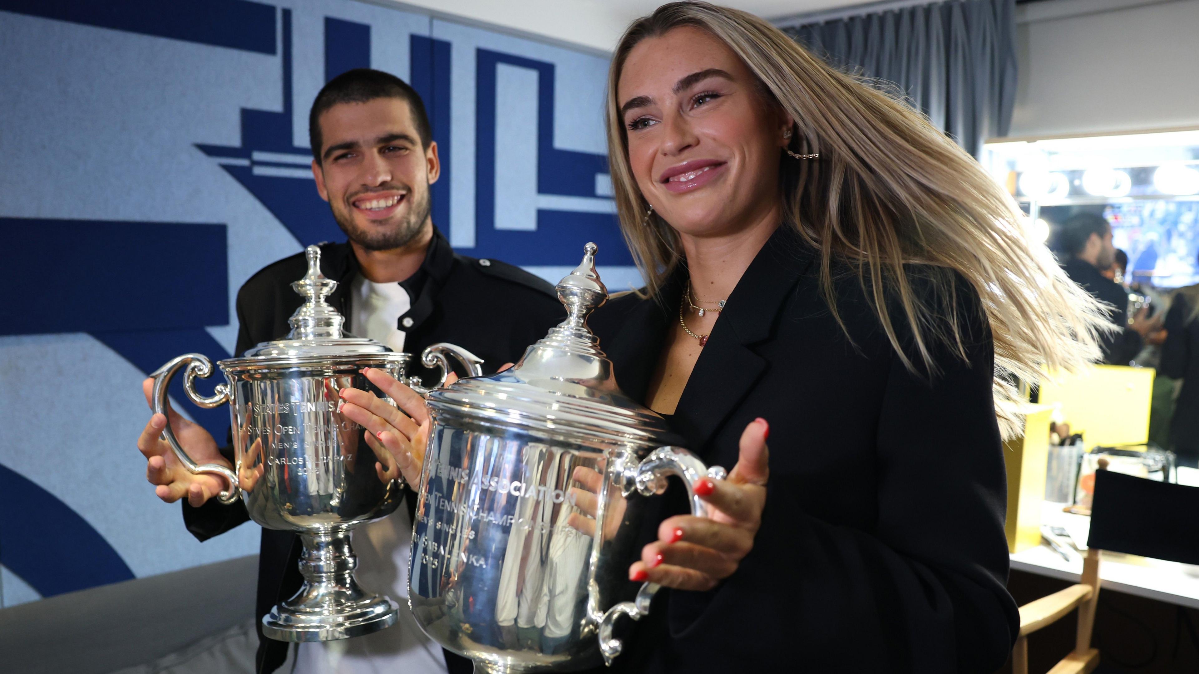 Carlos Alcaraz and Aryna Sabalenka pose with their US Open singles trophies