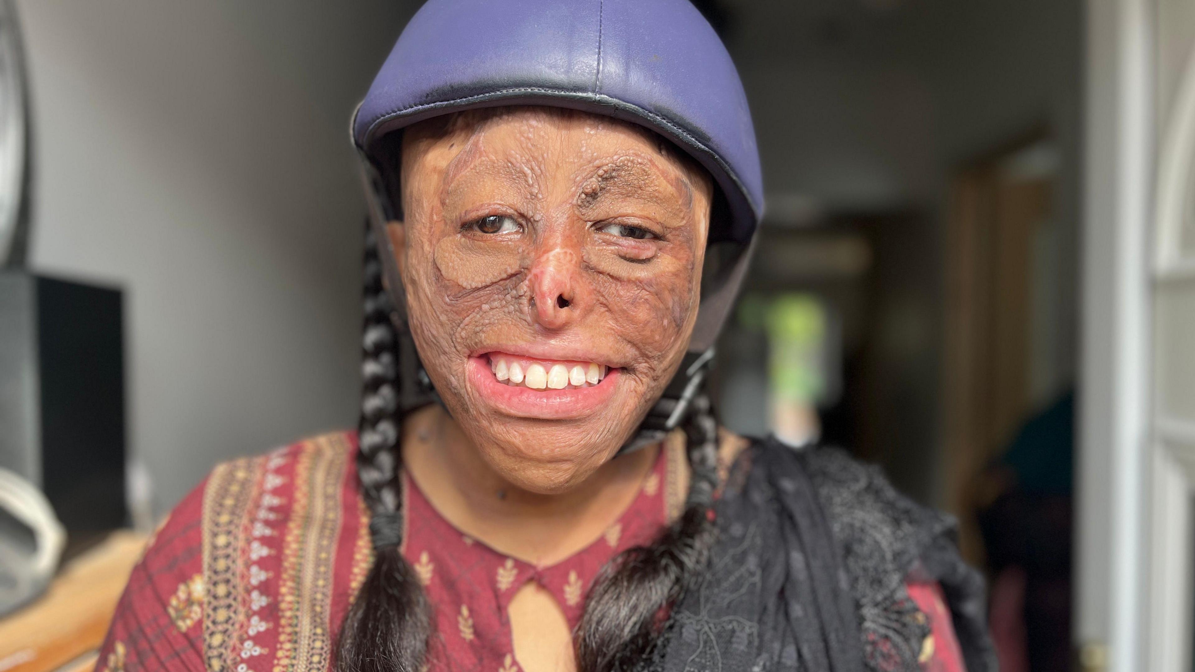 Shamiam Arif wearing her protective helmet and smiling at the camera