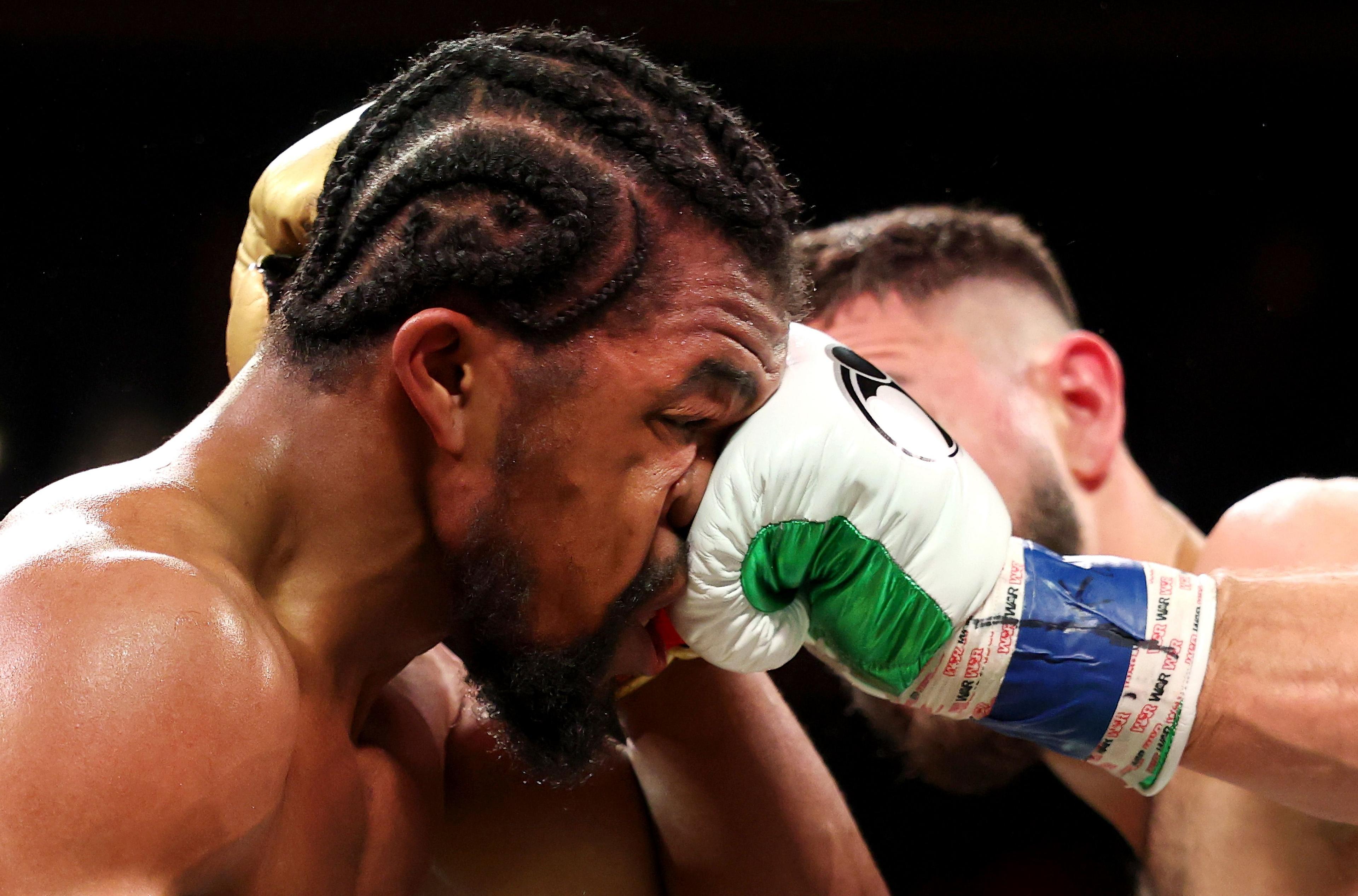 Gary Antuanne Russell absorbs a punch from Jose Valenzuela during their bout for Valenzuela's WBA junior welterweight title at Barclays Center in New York City