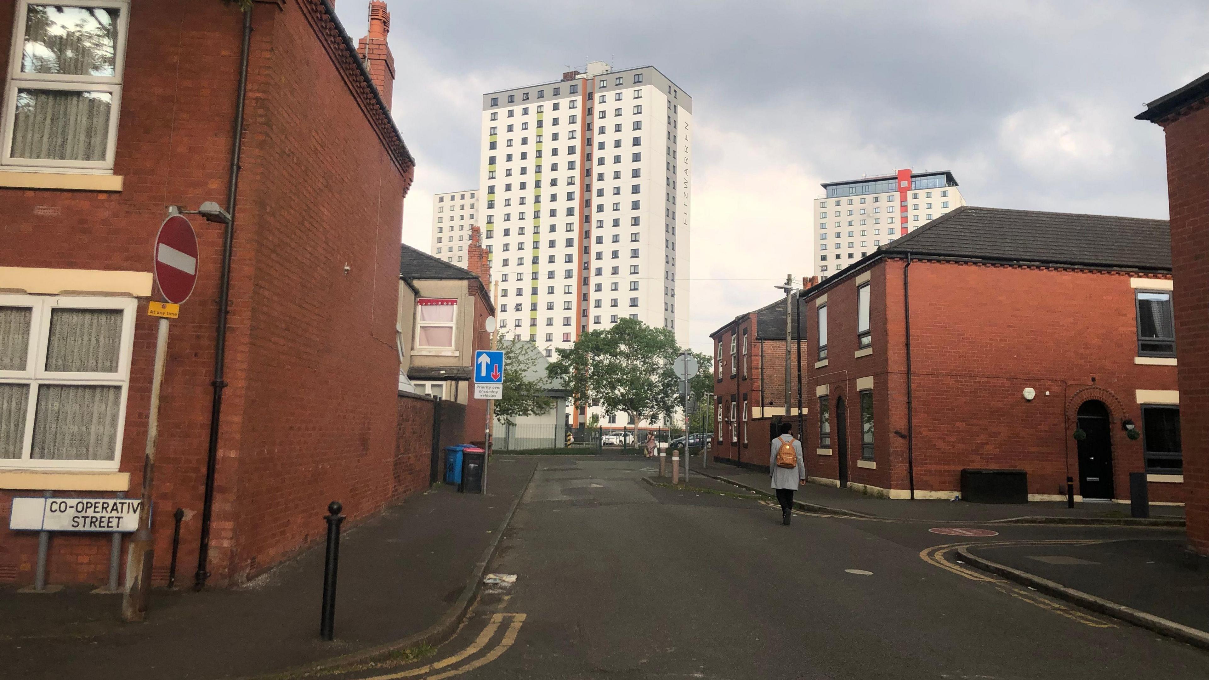 A woman walks down a street in Langworthy, Salford