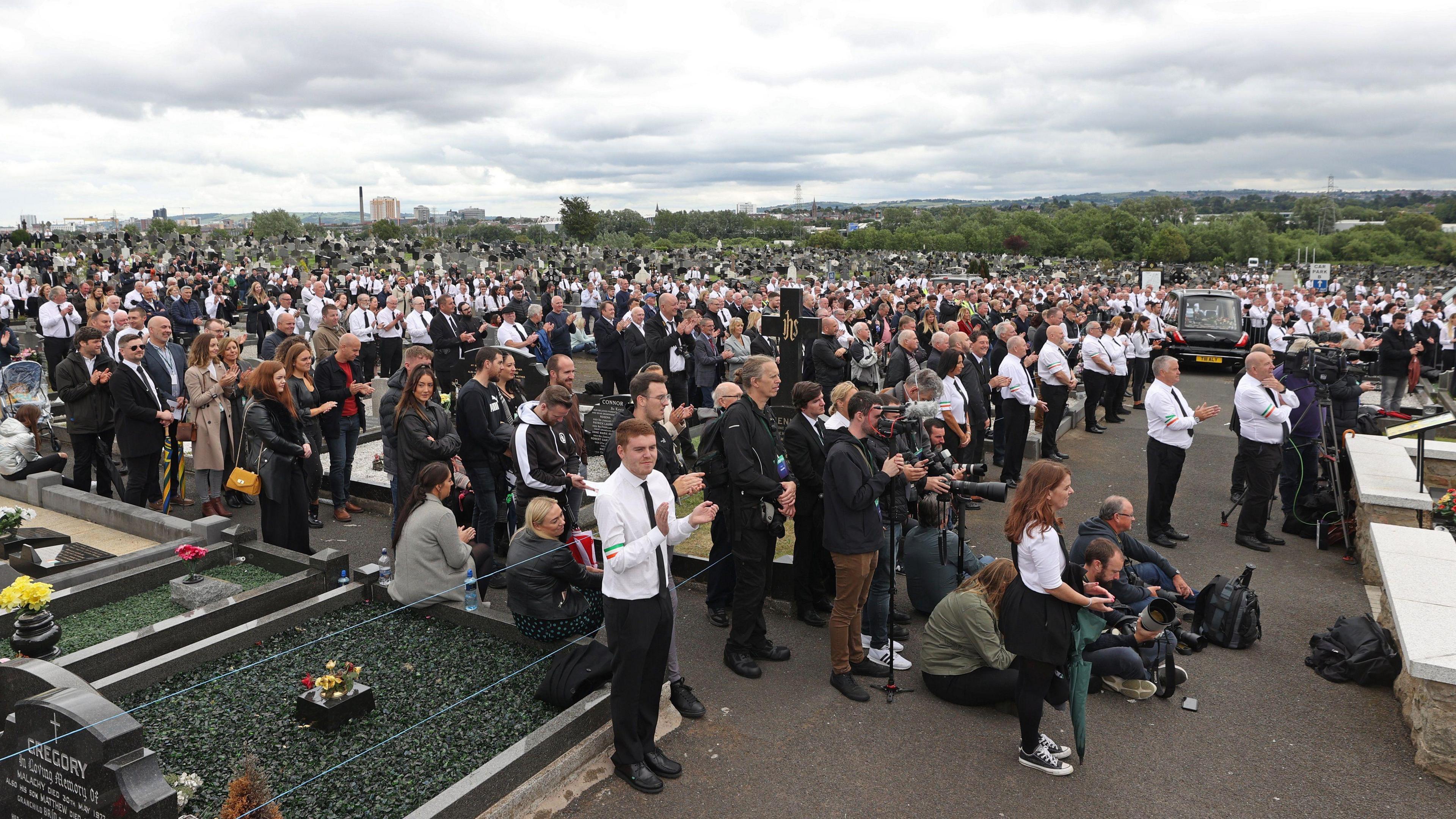 A large crowd of mourners listening to speeches in Milltown Cemetery during the funeral of Bobby Storey in June 2020.