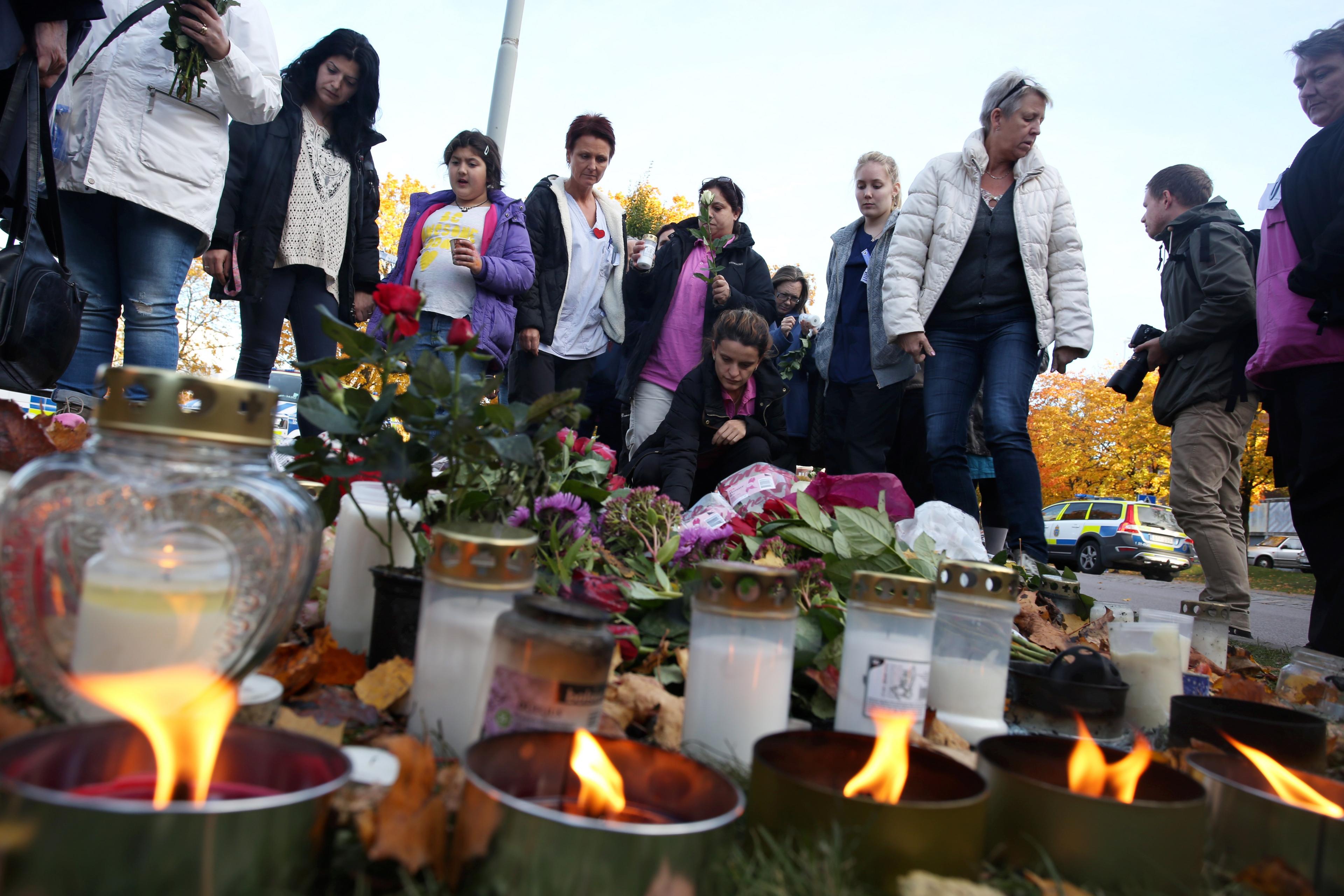 People light candles outside Kronan school in Trollhattan, Sweden, Friday Oct. 23, 2015, following a knife attack on Thursday