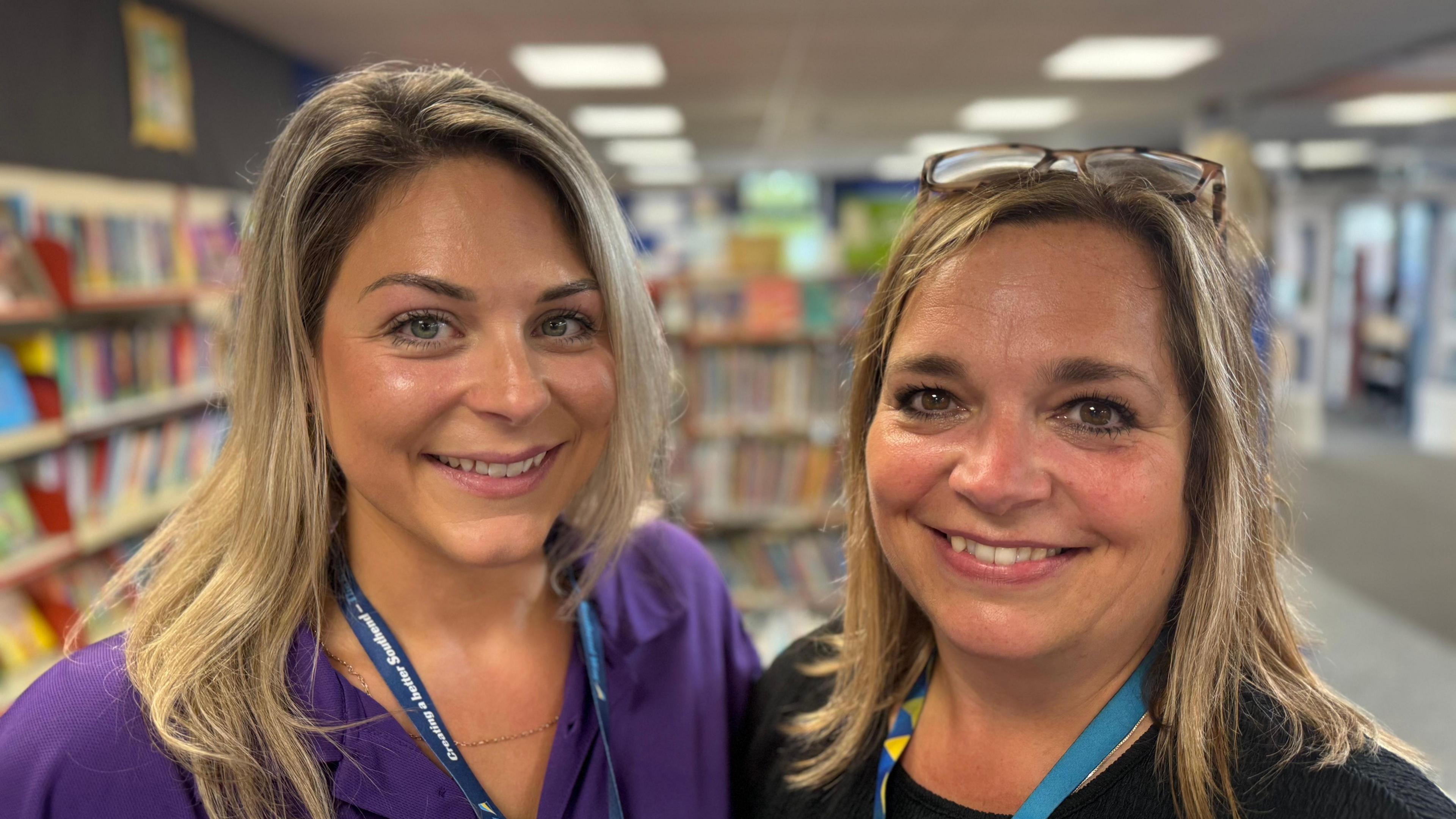 Two women smiling in a library