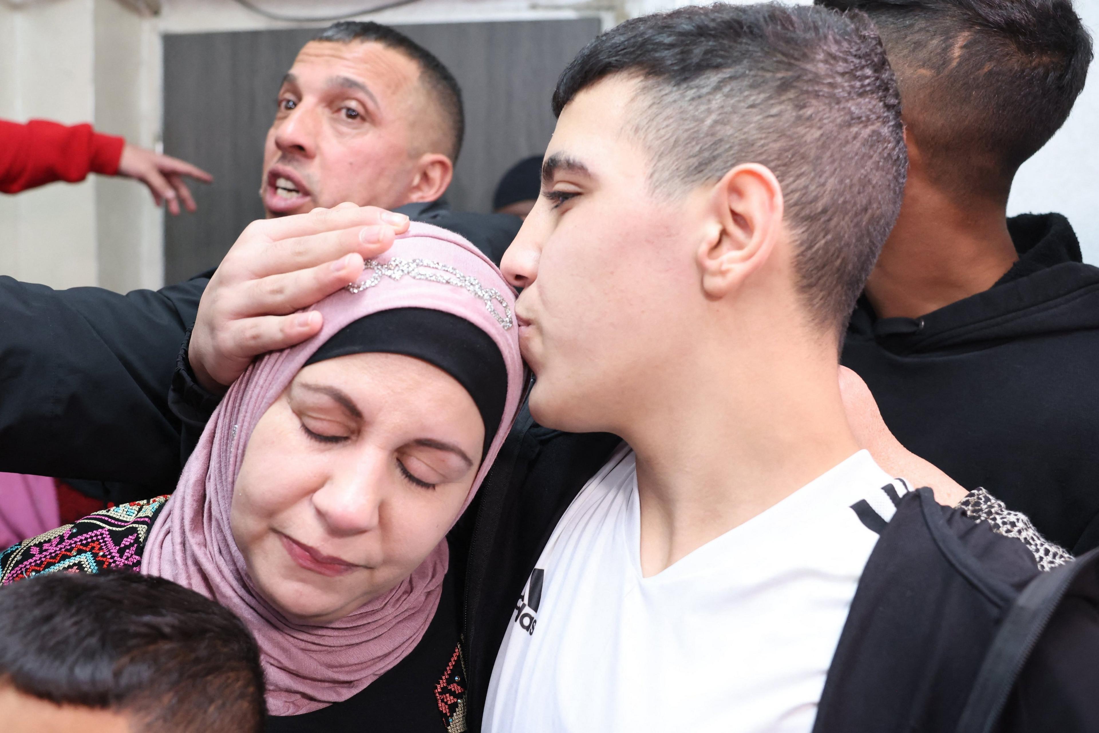 A boy, Ahmen Salayme, kisses his mother