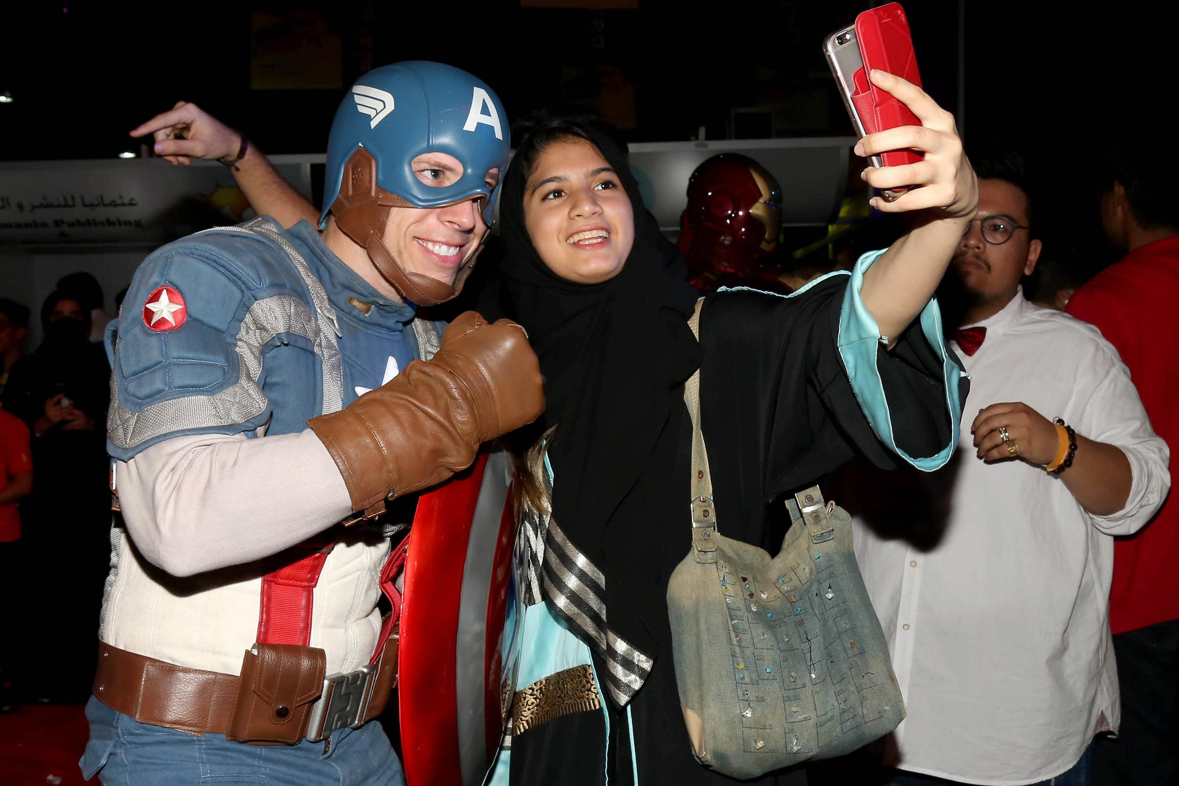 A woman poses for a selfie with a man dressed as Captain America during the Jeddah Comic Con, in Jeddah, Saudi Arabia, 16 February 2017