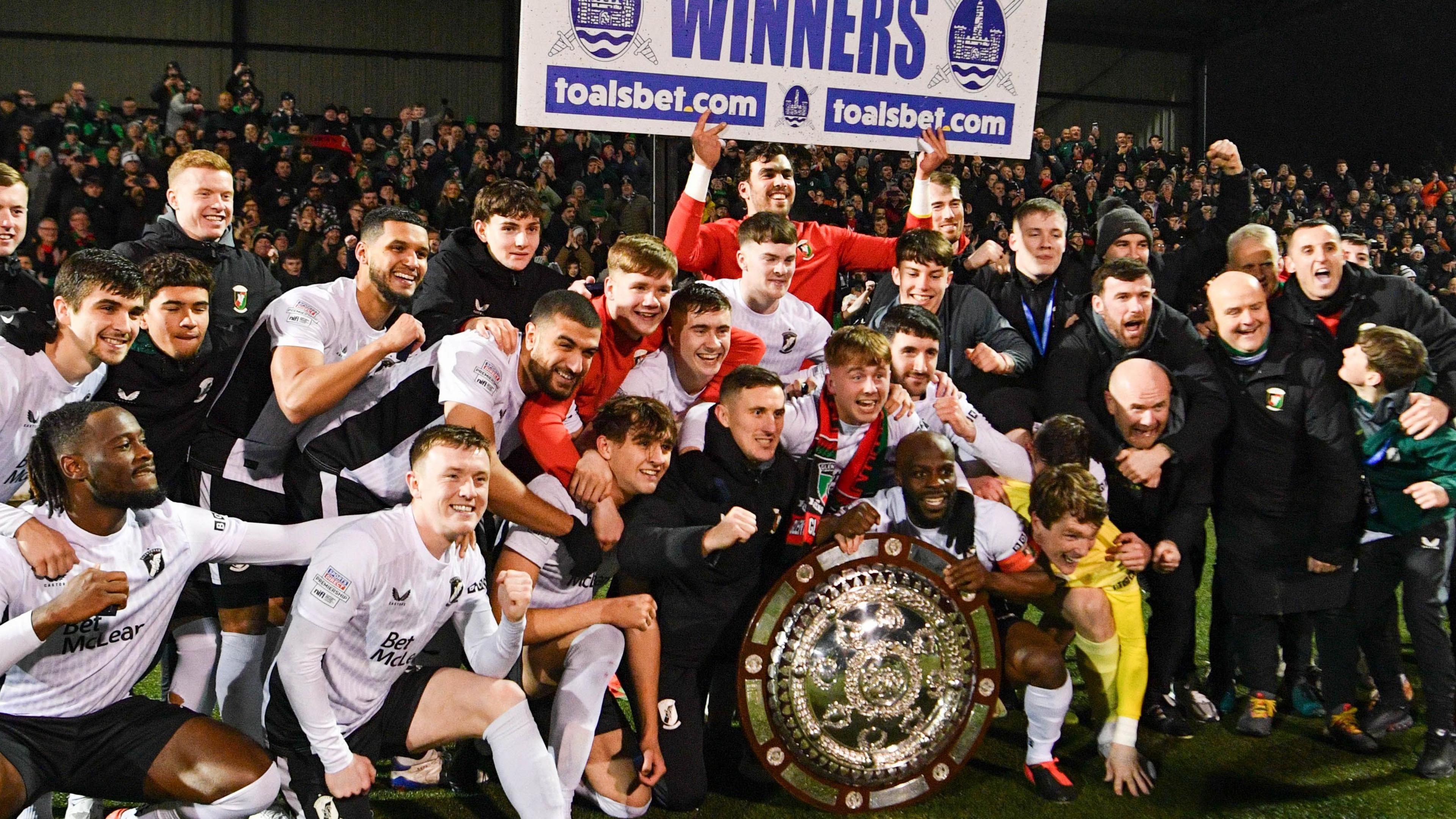 Glentoran players and staff celebrate with the County Antrim Shield