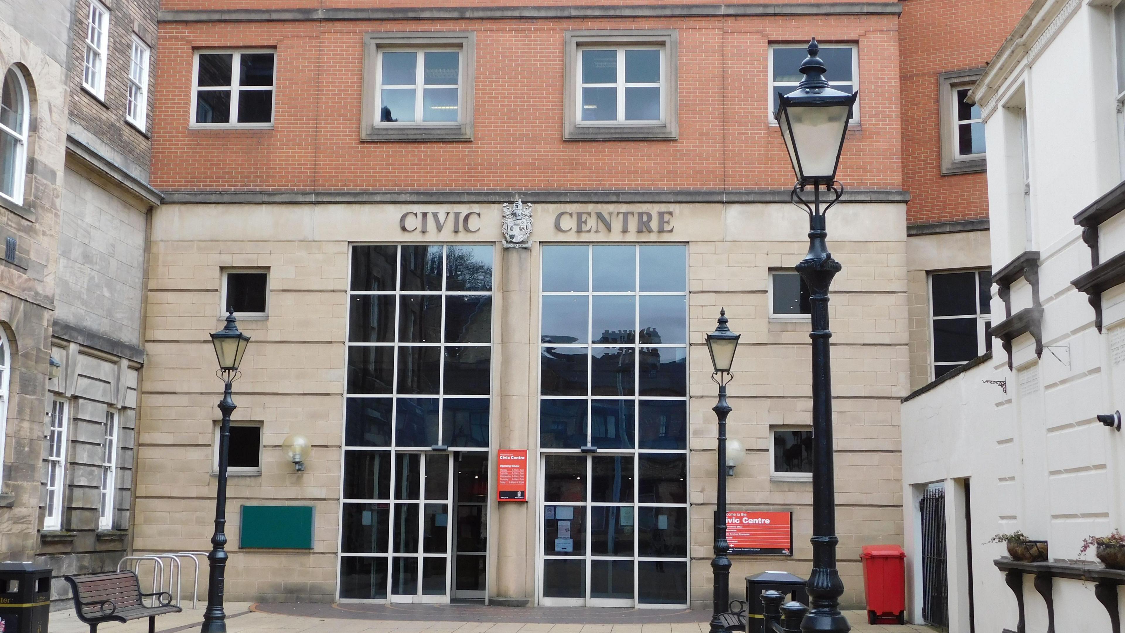 The front of Stoke on Trent city council's civic centre. it has large windows with a glass door.