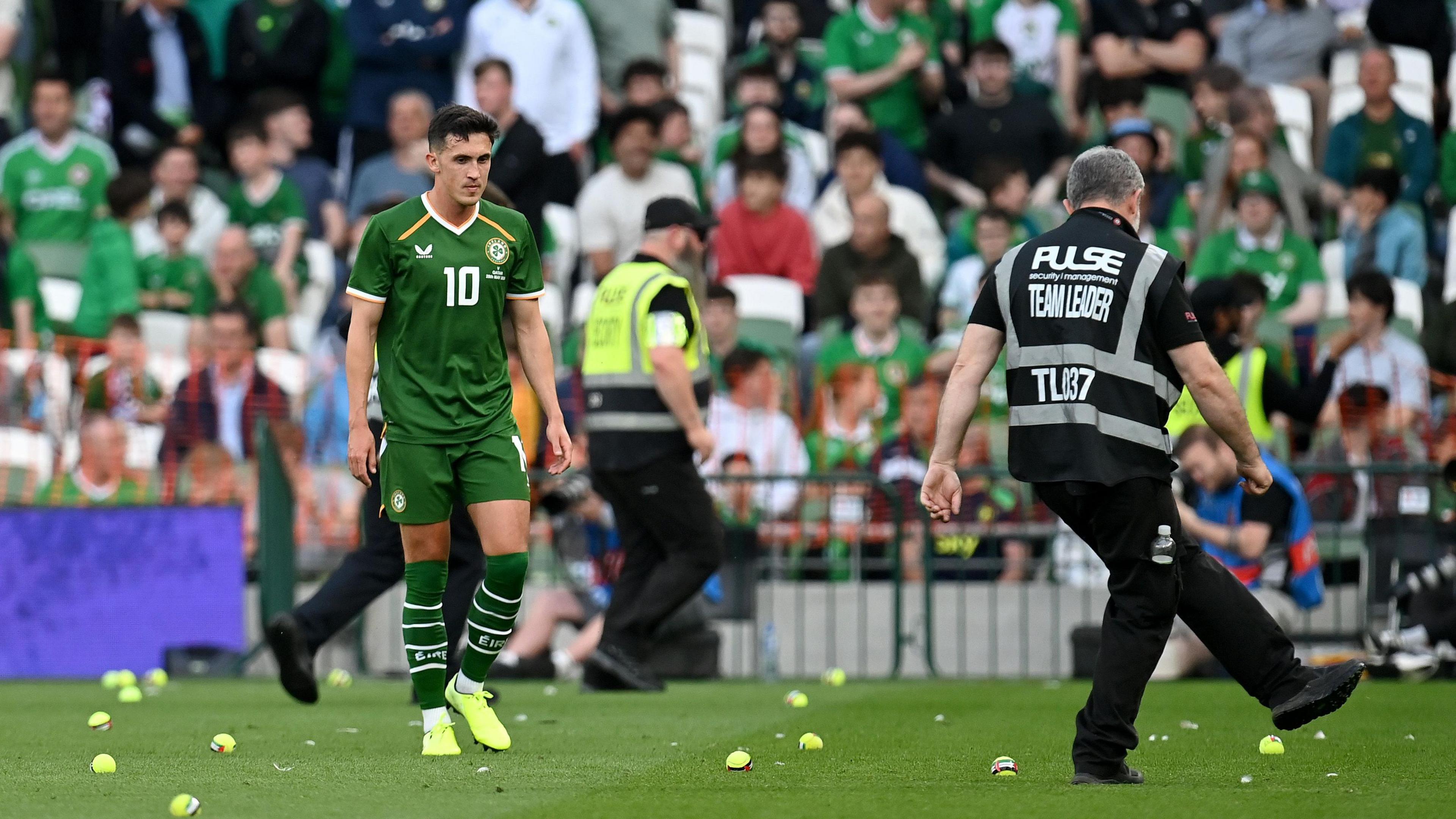 Republic of Ireland midfielder Jamie McGrath surrounded by tennis balls with the Palestinian flag on them as a steward tries to keep some away