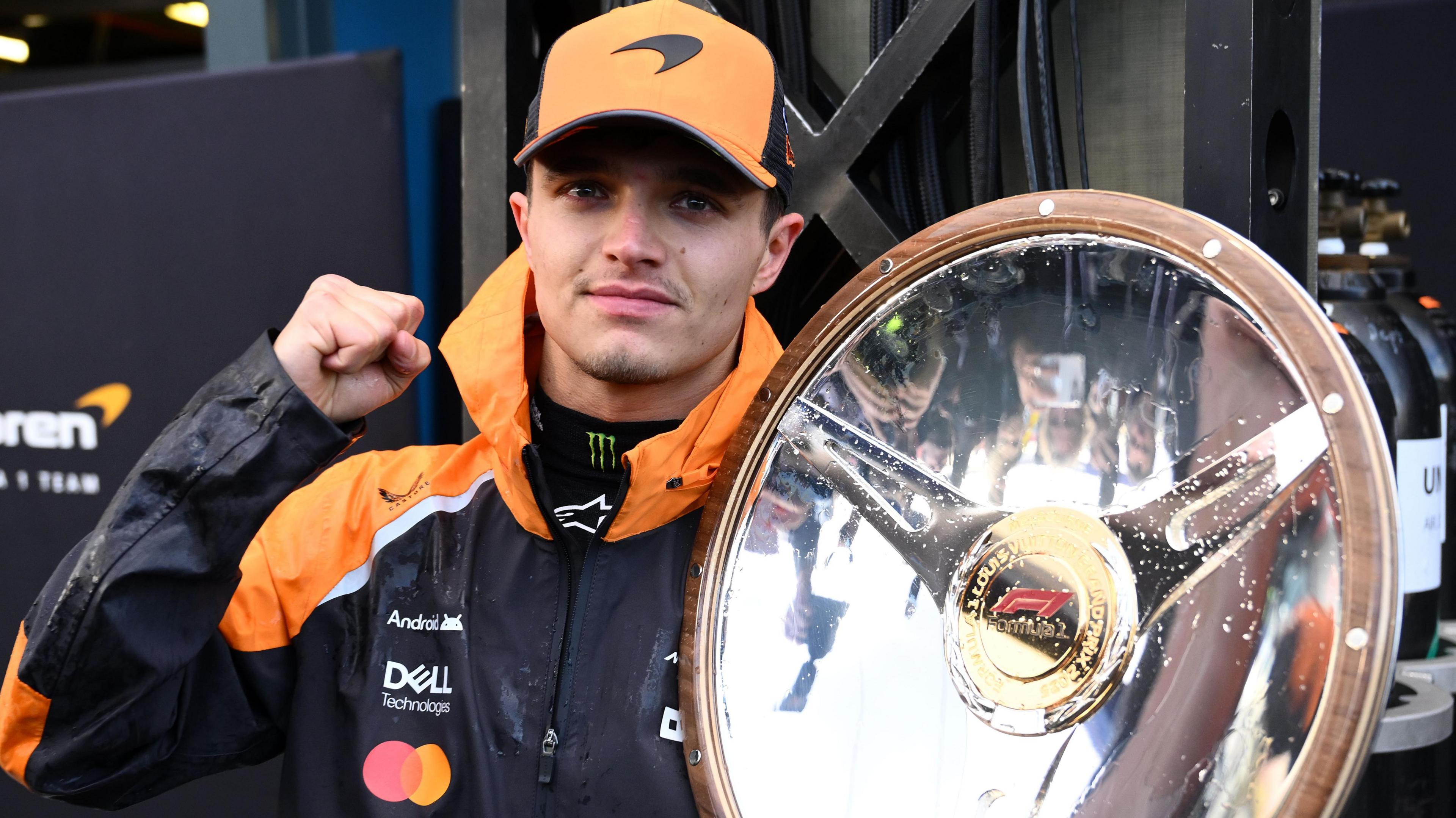 McLaren's Lando Norris holds the winner's trophy for the Australian Grand Prix in his left hand while clenching his fist in celebration with his right