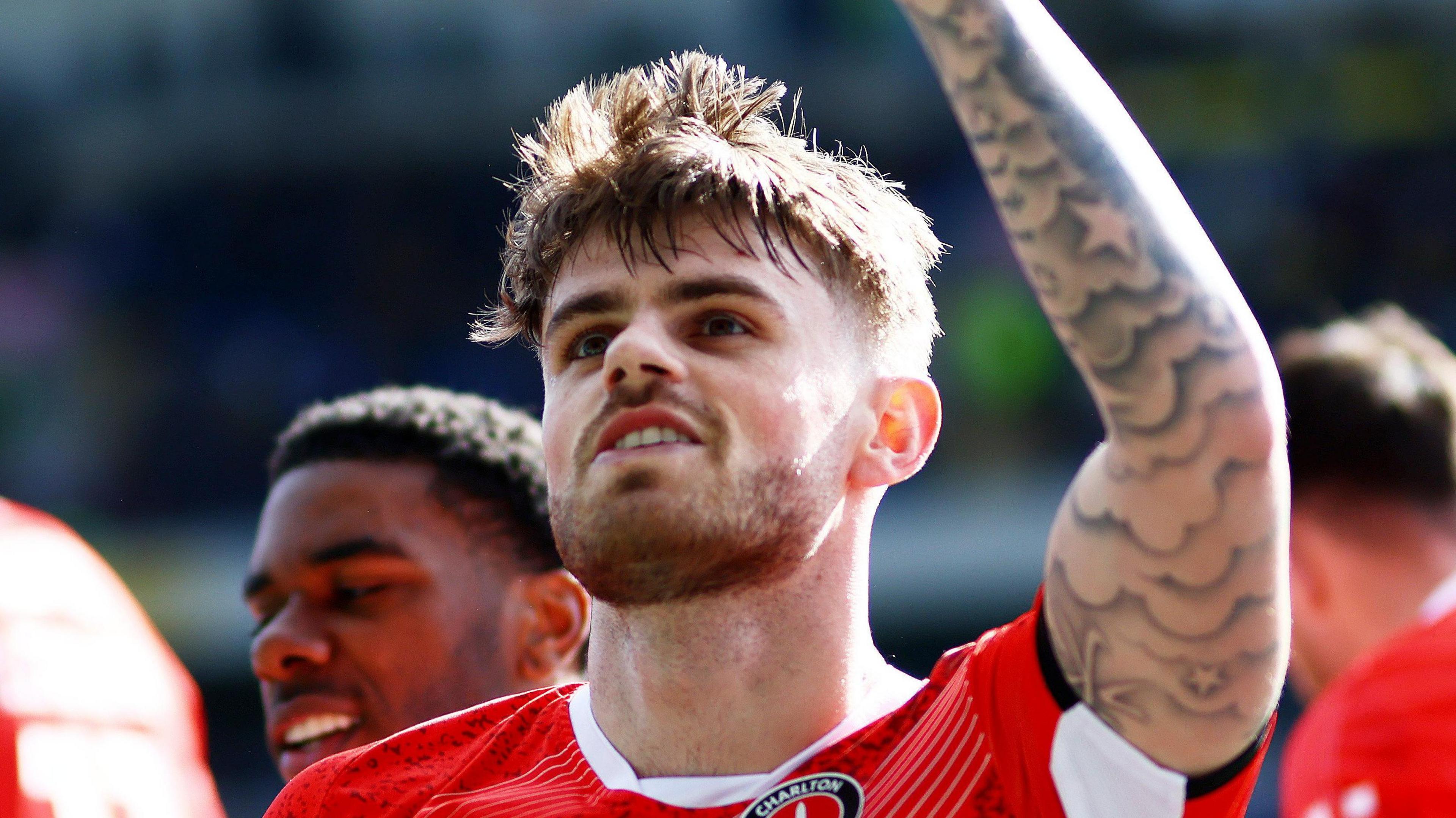 Charlie Kelman raises his left arm into the air to celebrate scoring his equalising penalty for Charlton.