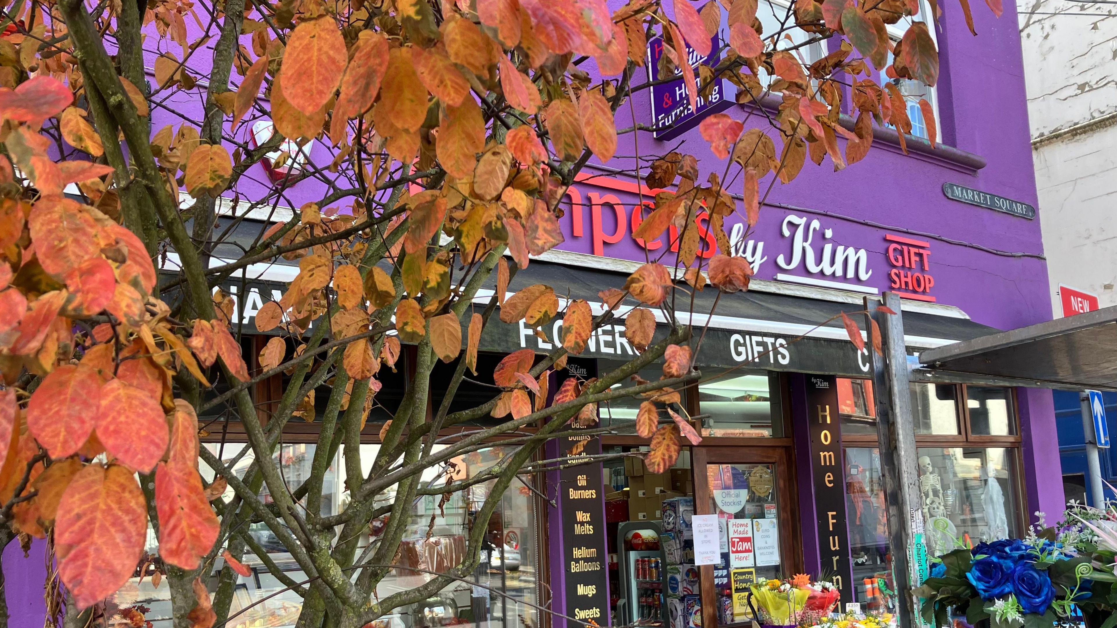 The owners of a purple shop front building with autumnal flowers outside which did not apply for funding