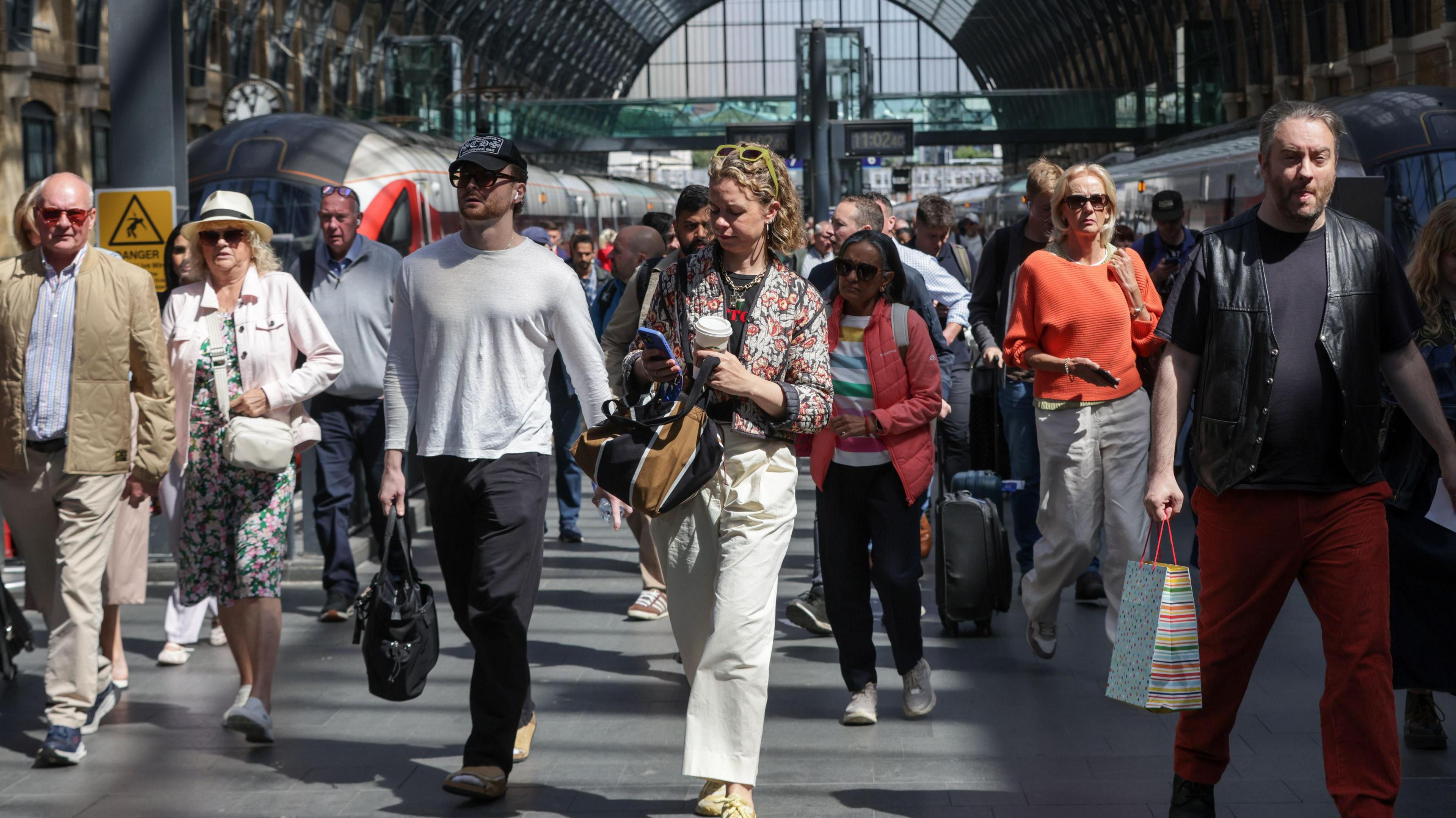 A group of people walk through King's Cross Station in London.