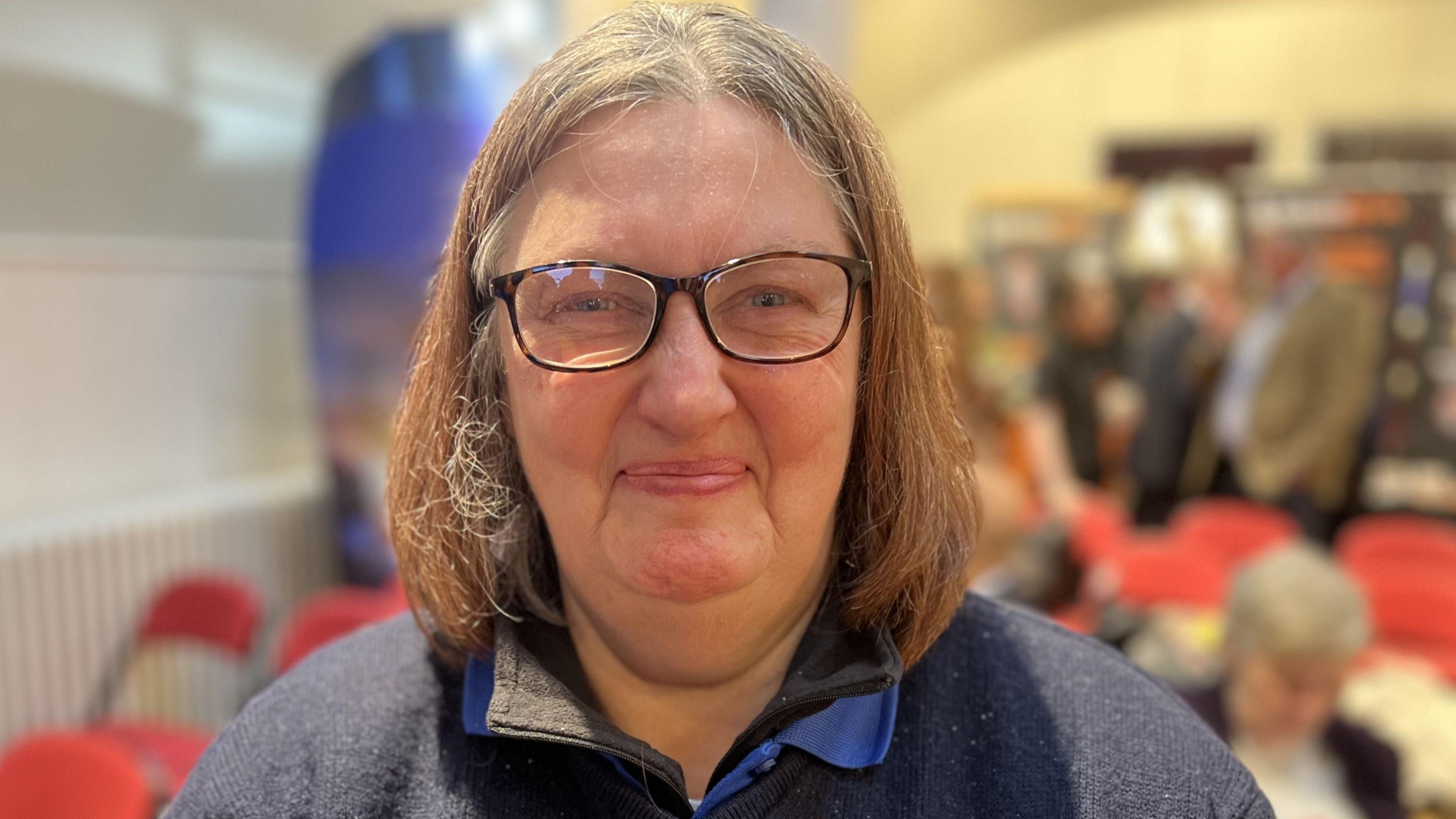 Bernice Ghazvin smiling with shoulder length brown hair and brown rimmed glasses