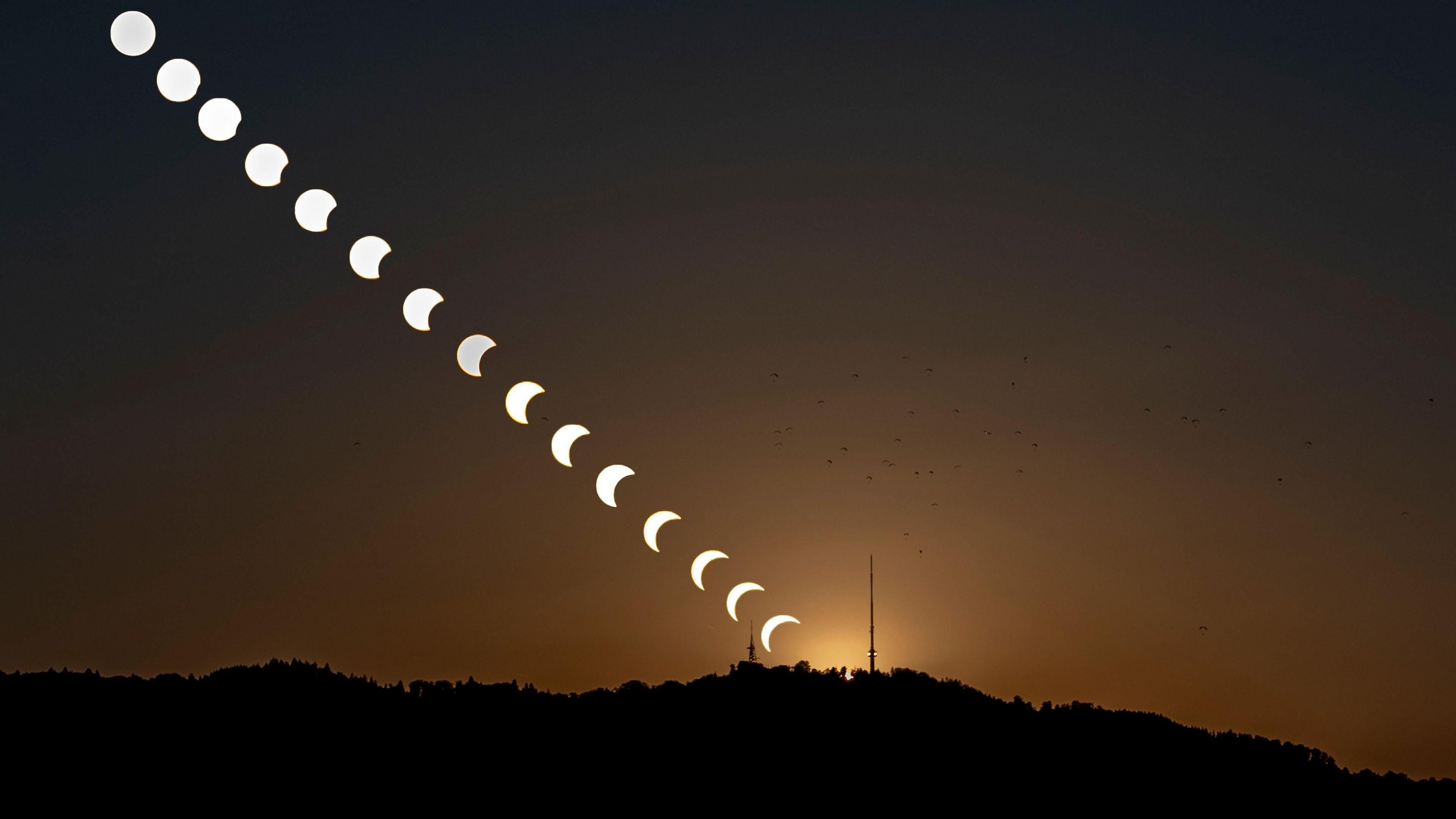 A composite image created by combining 16 separate photographs as the moon obscures the sun during a partial solar eclipse over the Uetliberg in Zollikon, Switzerland, 12 August 2026 .