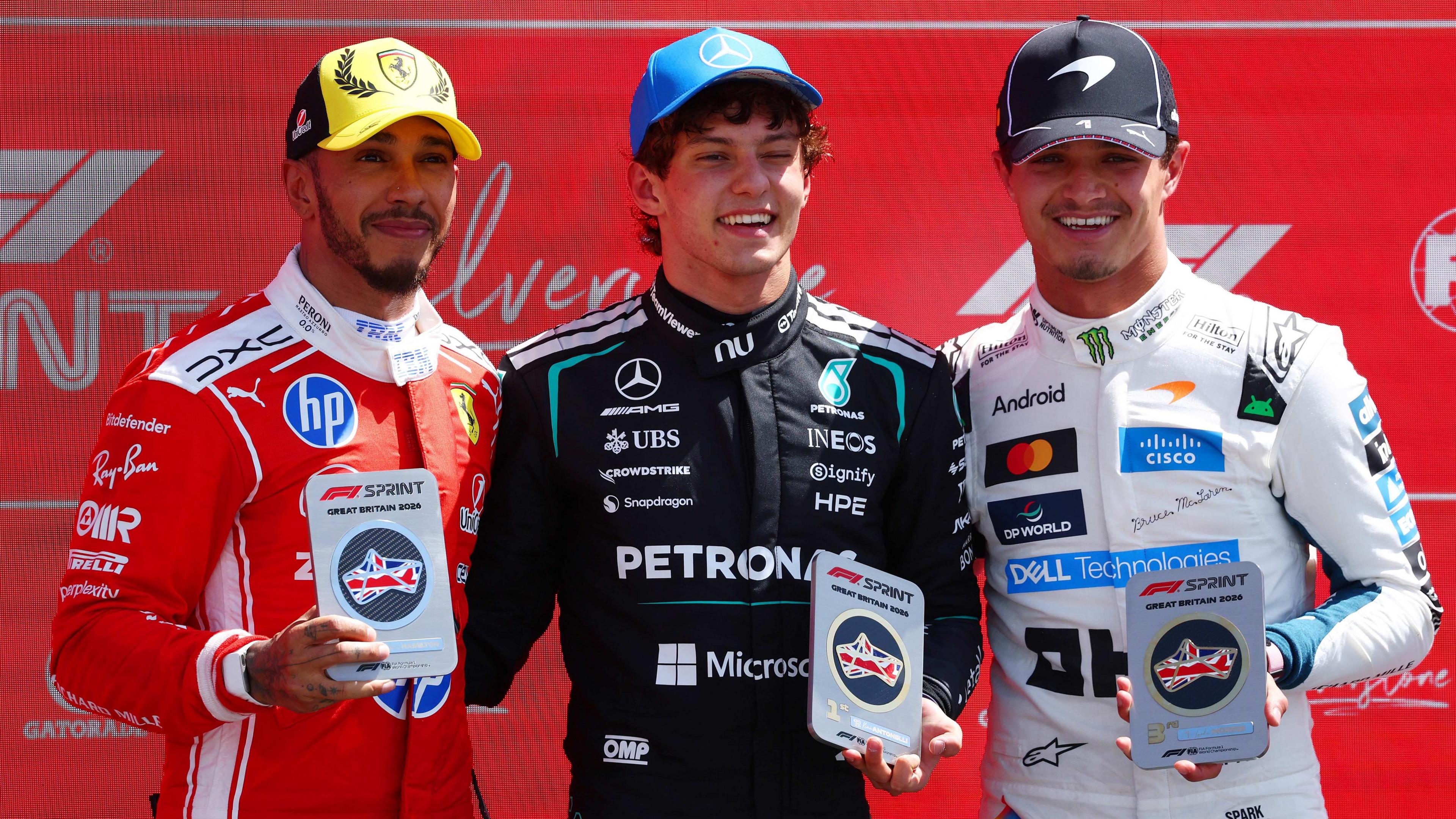 The top three of the British Grand Prix sprint race - Kimi Antonelli, Lewis Hamilton and Lando Norris - pose for pictures with their trophies