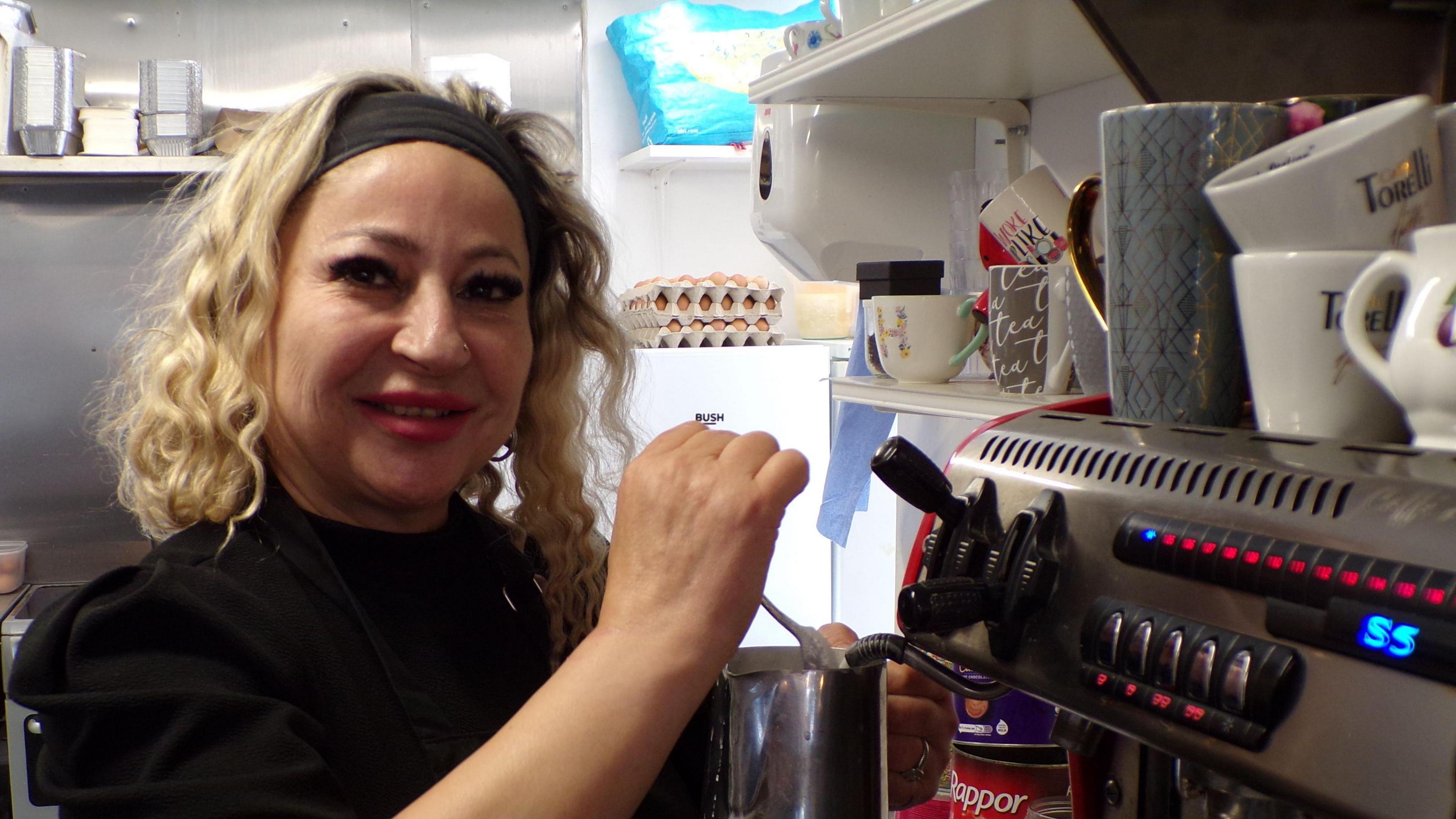 A woman pictured by a coffee machine