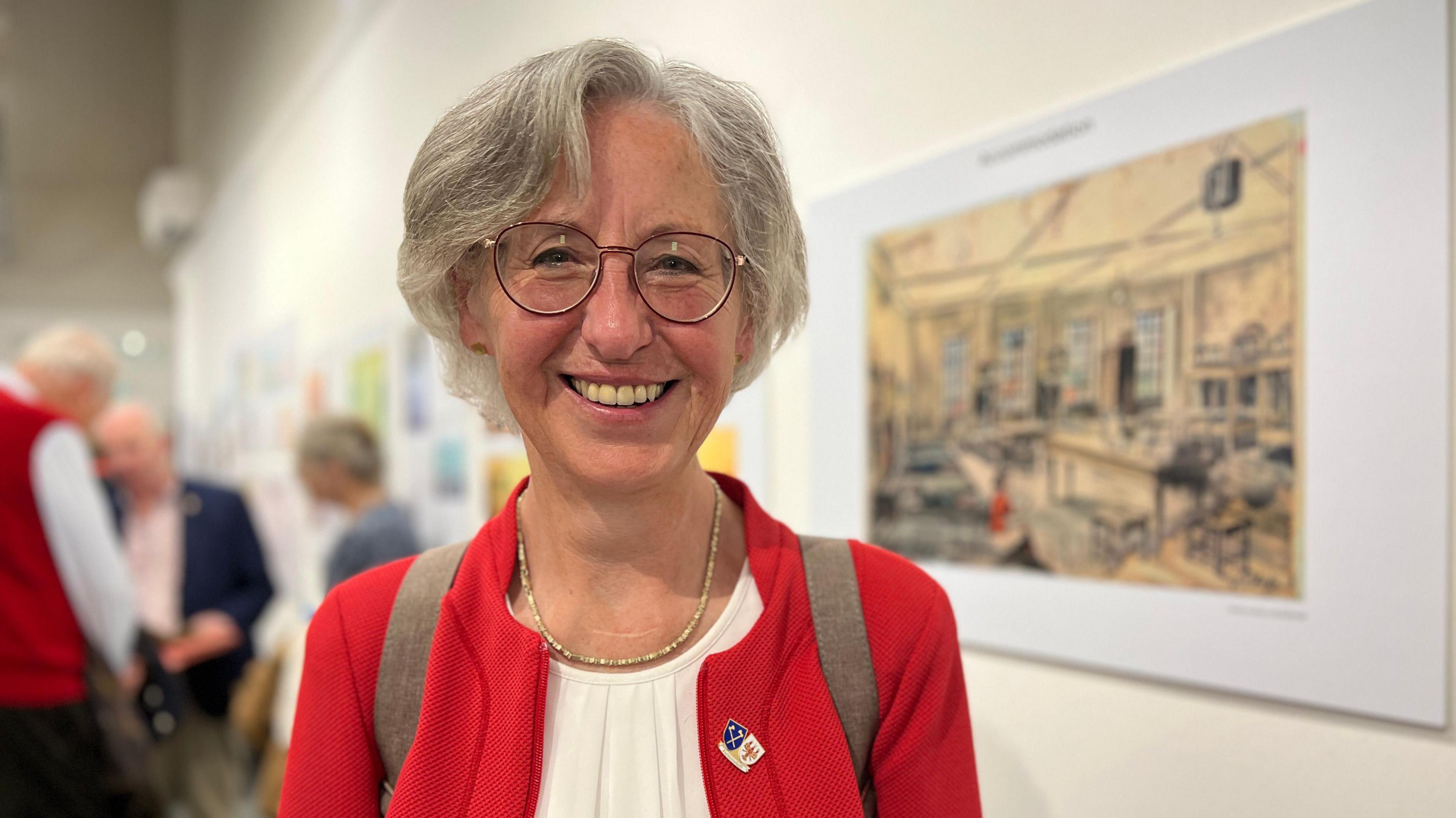 Giselsa smiles at the camera with the exhibition in the background