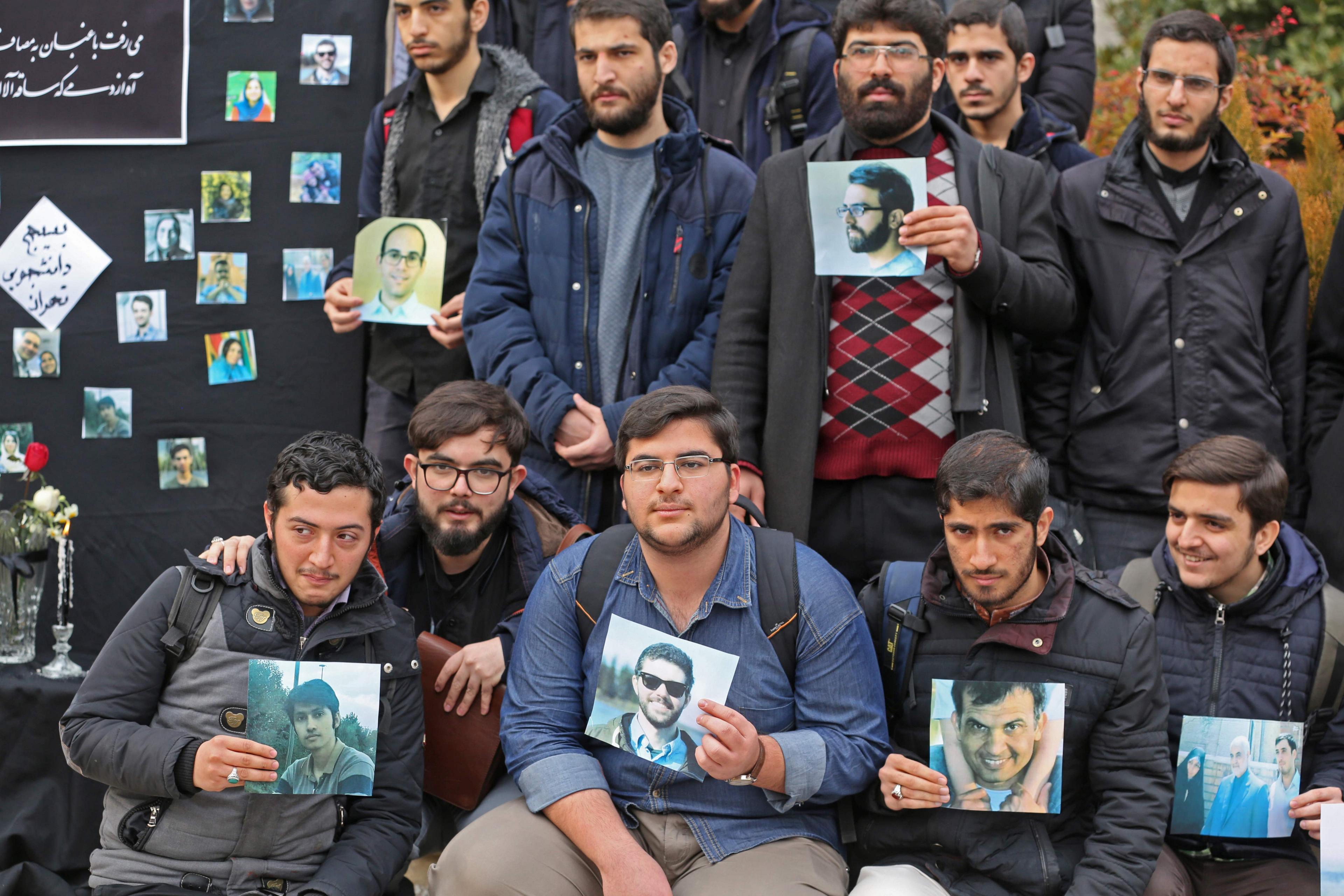 Iranian students hold pictures of victims during a memorial for the passengers of the Ukraine plane crash, in University of Tehran on January 14, 2020