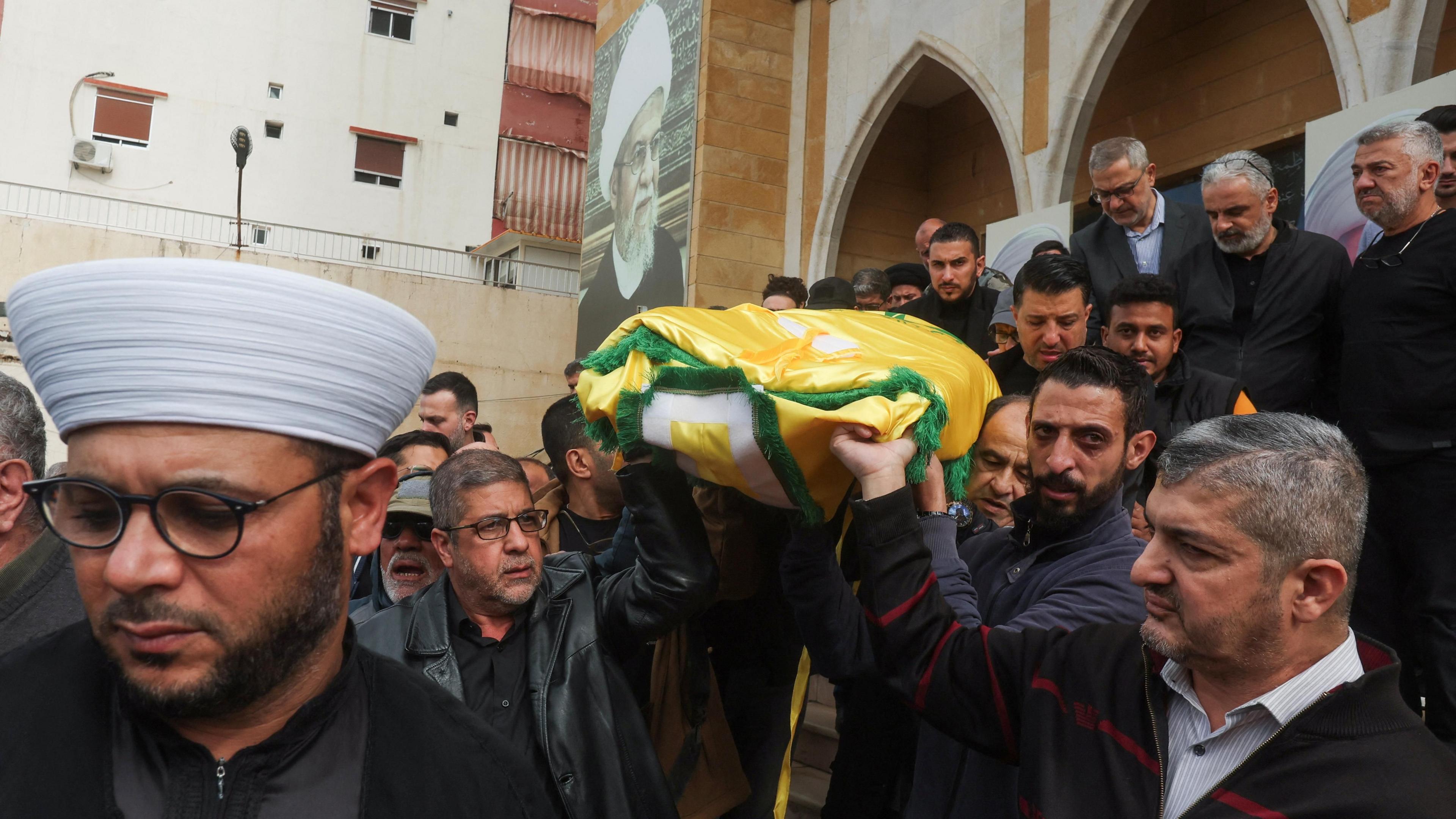 Mourners carry the body of Hezbollah's spokesman Mohammed Afif, who was killed by an Israeli strike on a building in central Beirut, during his funeral in Sidon, southern Lebanon (18 November 2024)