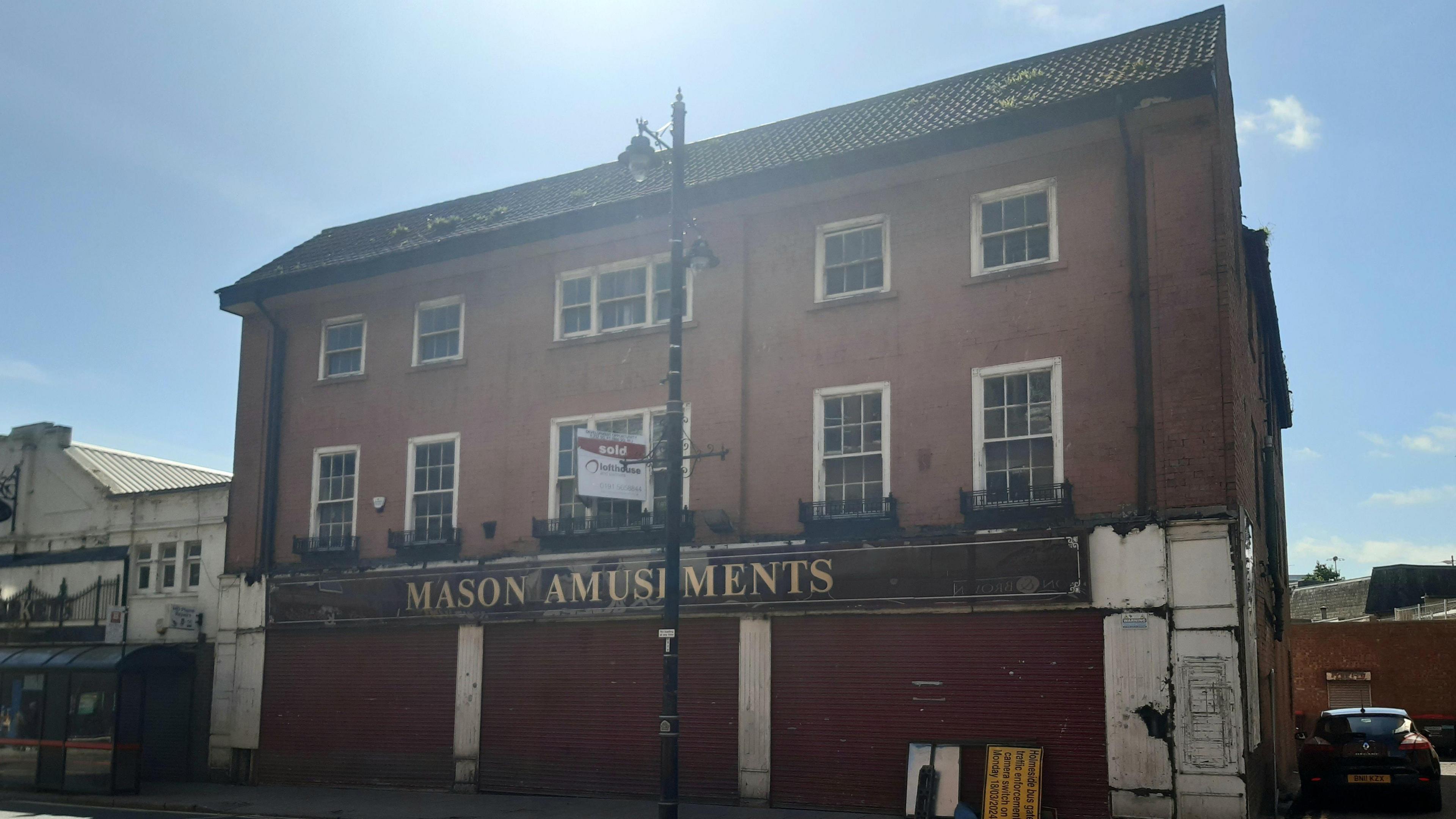 A general view of the former Mason Amusements building in Holmeside, Sunderland, with a 'sold' sign and closed shutters.