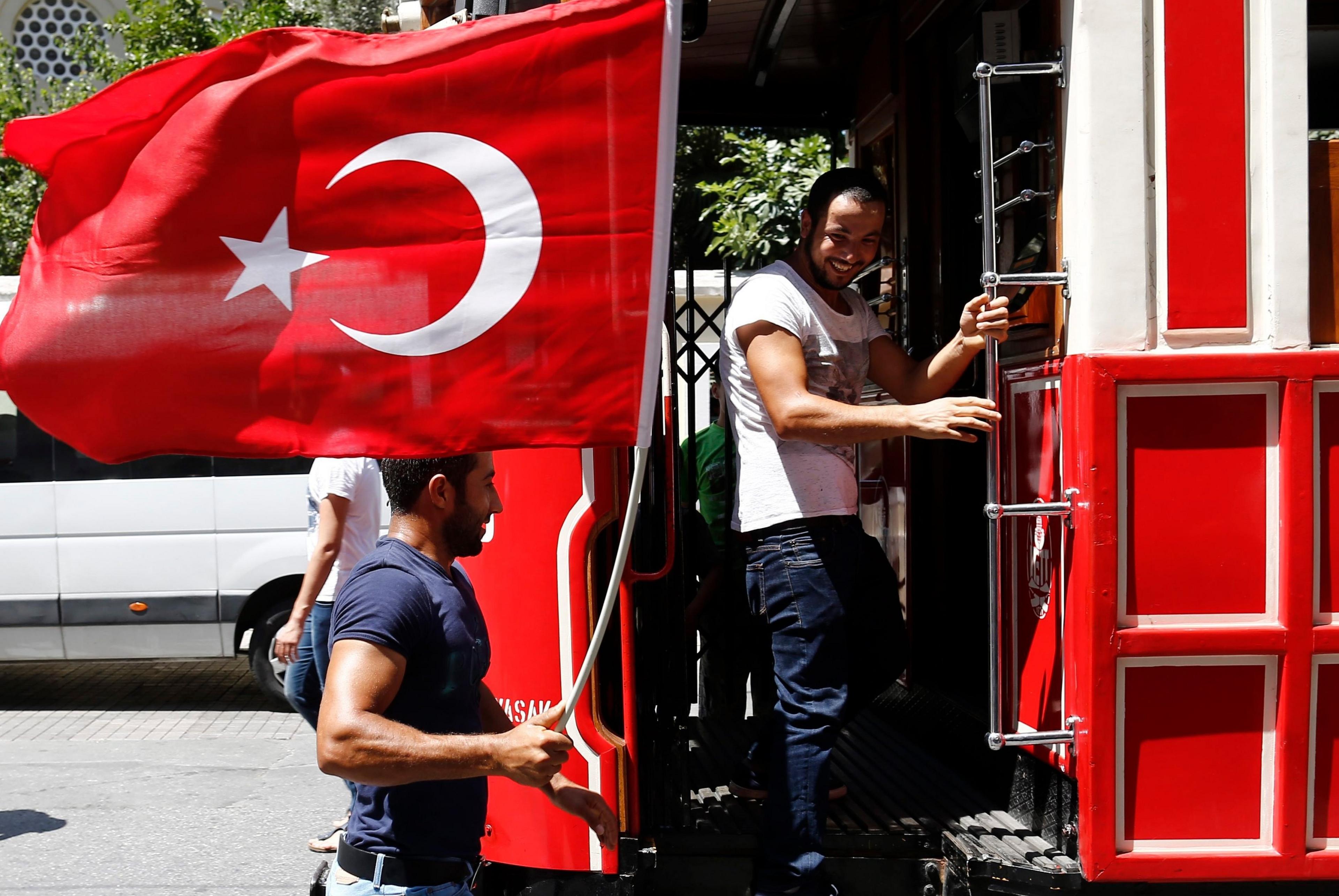 Man with flag by tram Istanbul's central Taksim Square on Saturday (16/07/2016)