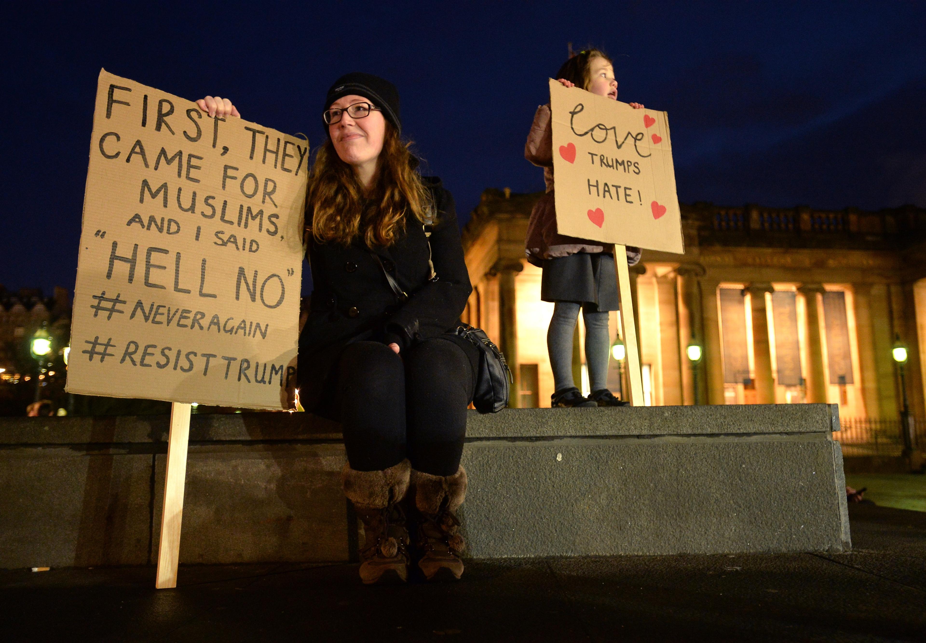 Demonstrators hold placards as they march from the Mound to the Scottish Parliament to protest against President Trump"s Muslim travel ban to the USA on January 30, 2017 in Edinburgh