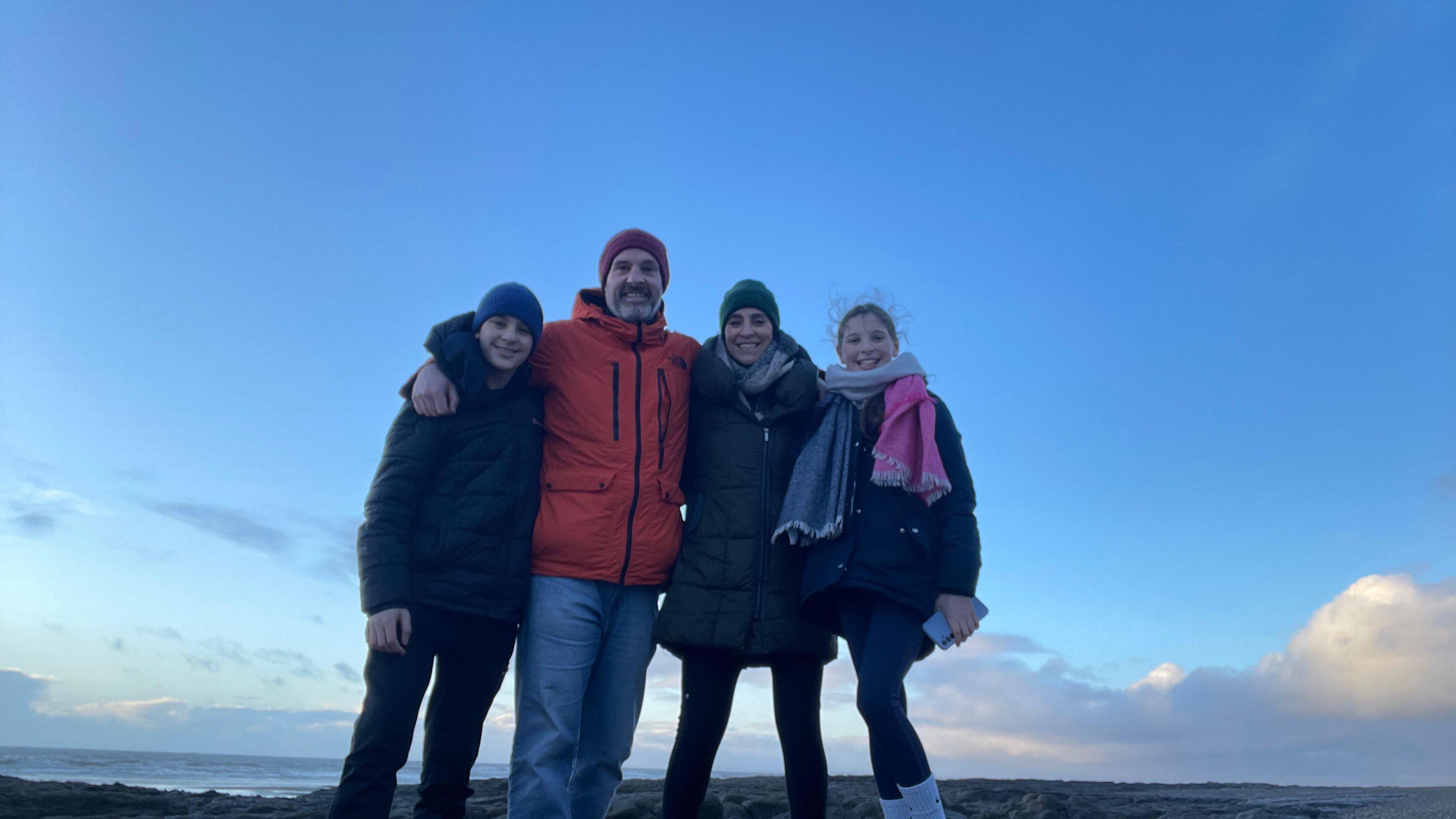 Beti and her family standing on top of a mountain. They are all wrapped up in warm clothes