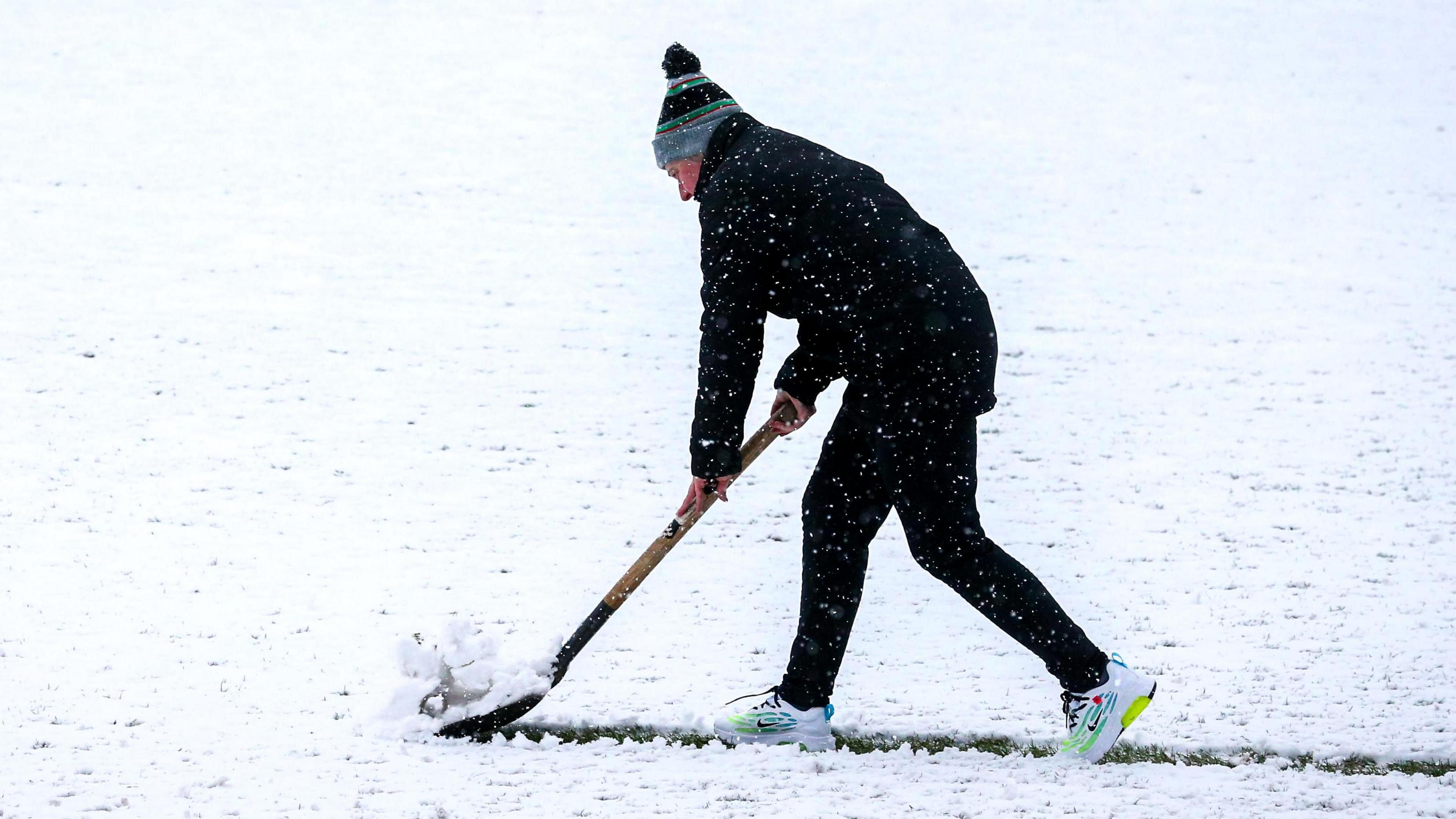 Grounds staff attempt to clear the pitch at the Oval