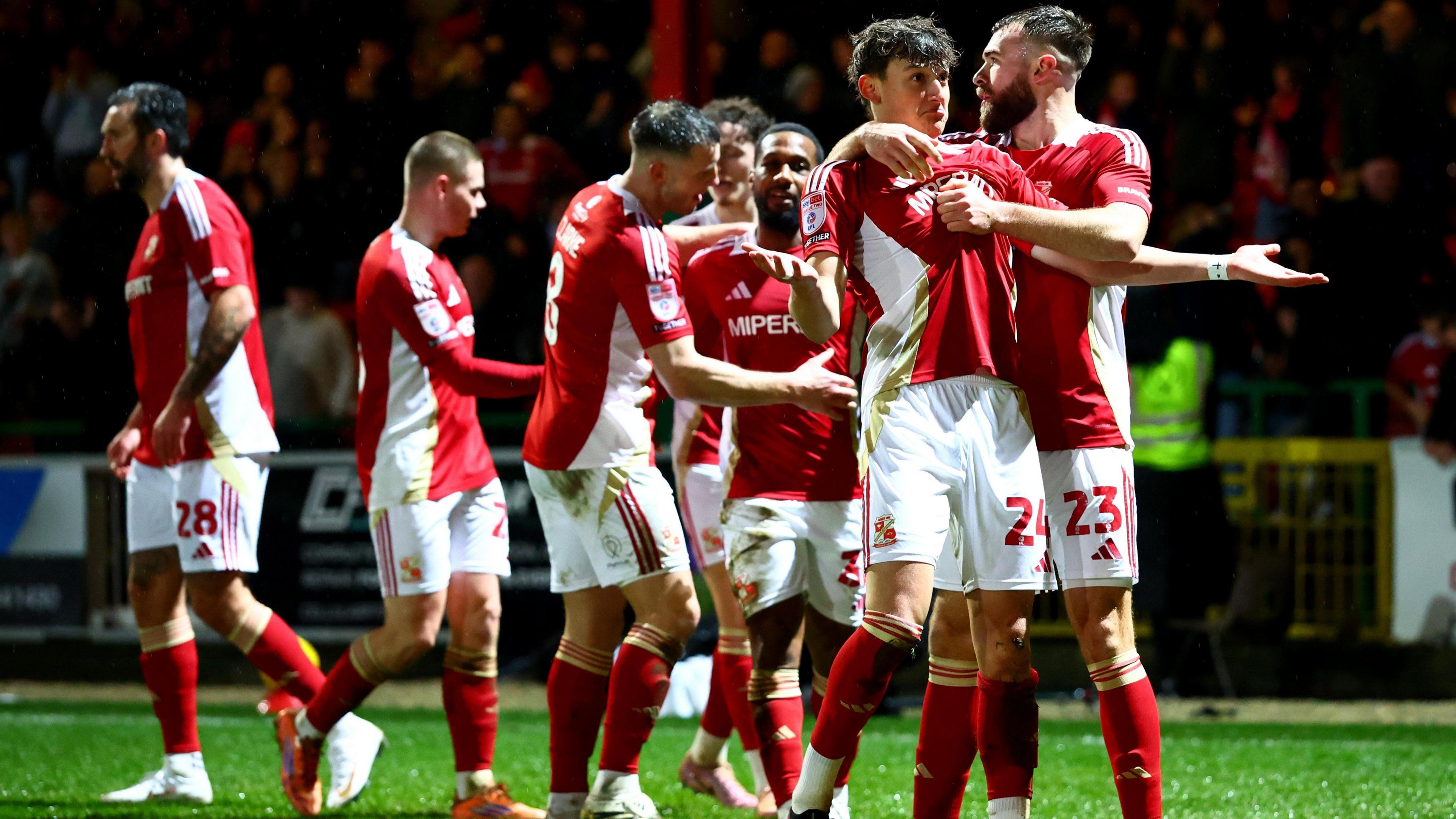 Fletcher Holman celebrates with Swindon Town teammates