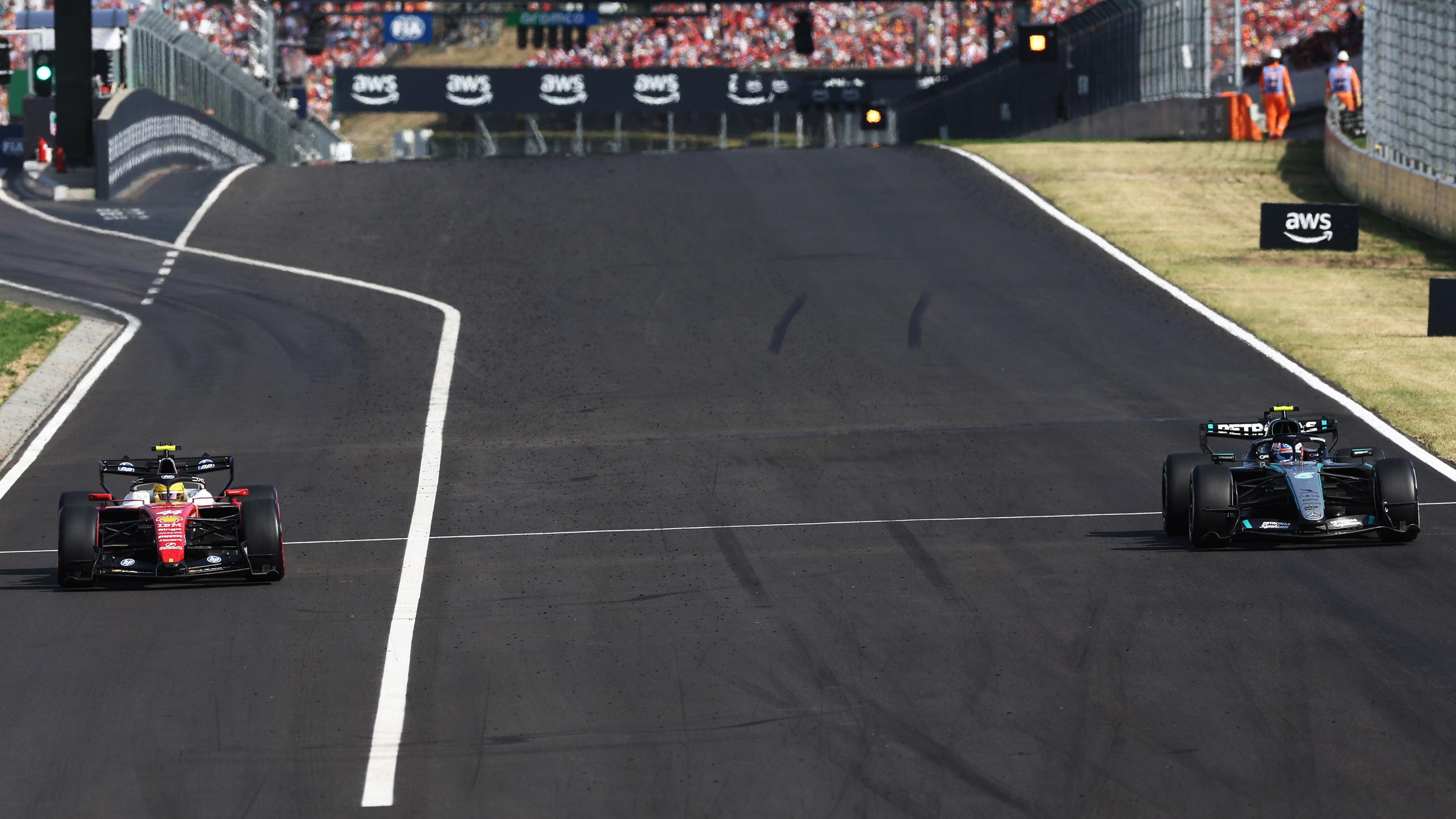 Ferrari's Lewis Hamilton emerges from the pit lane as Mercedes' Kimi Antonelli comes down the start-finish straight during the Hungarian Grand Prix