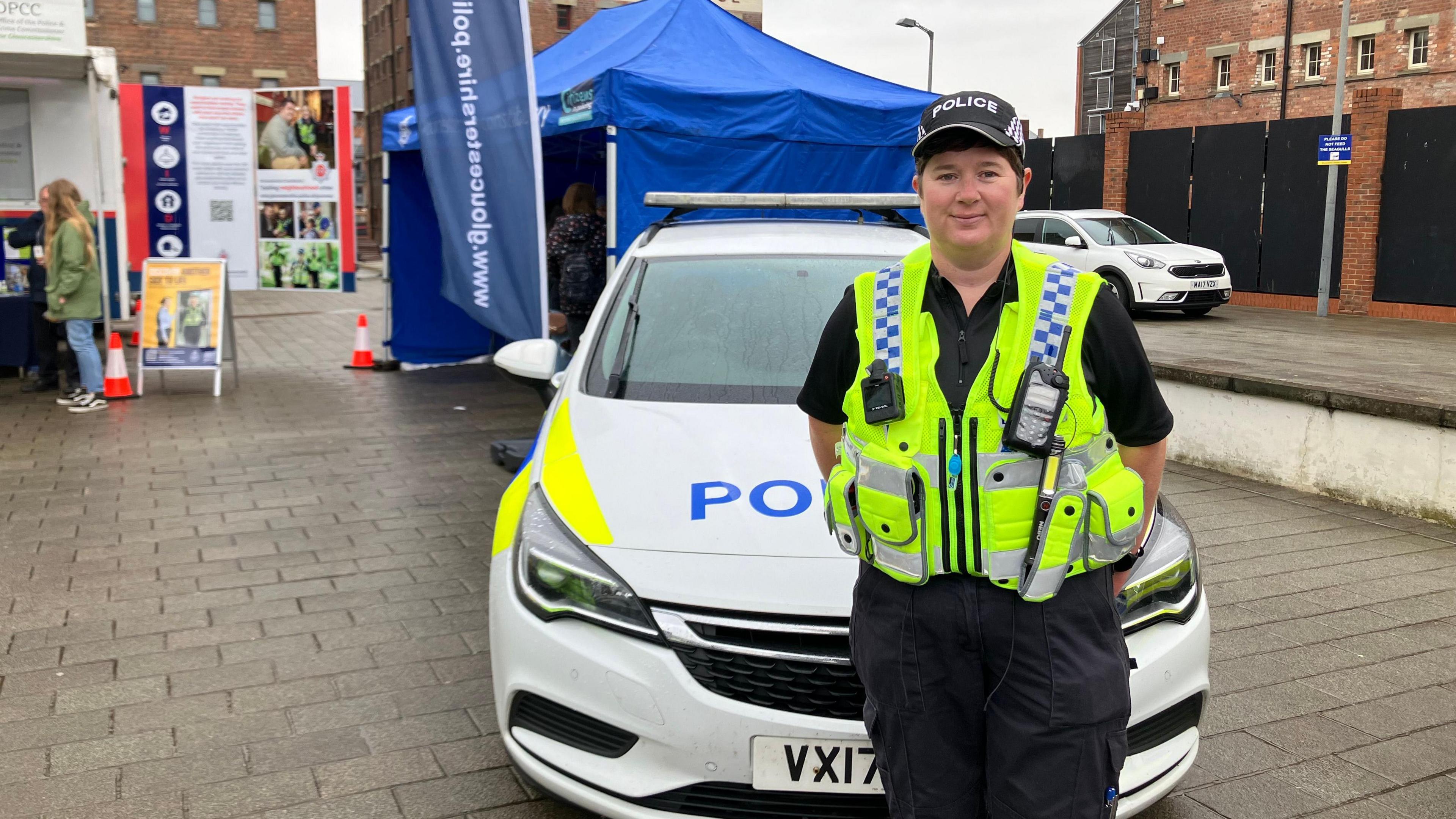 Special police constable Linda O'Brien standing at the event in front of a police car. 