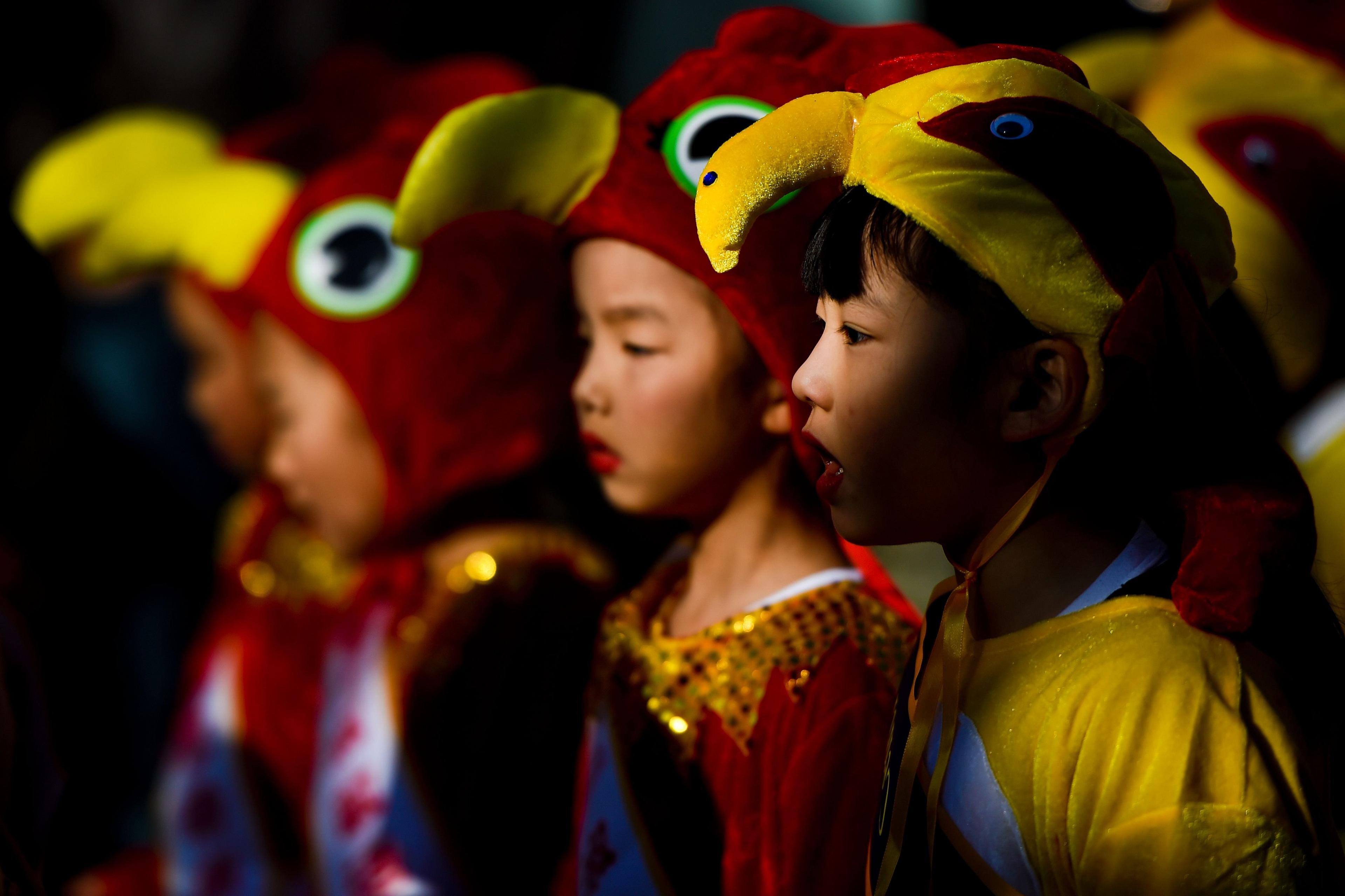 Children dressed up in rooster costumes in celebration of Chinese New Year