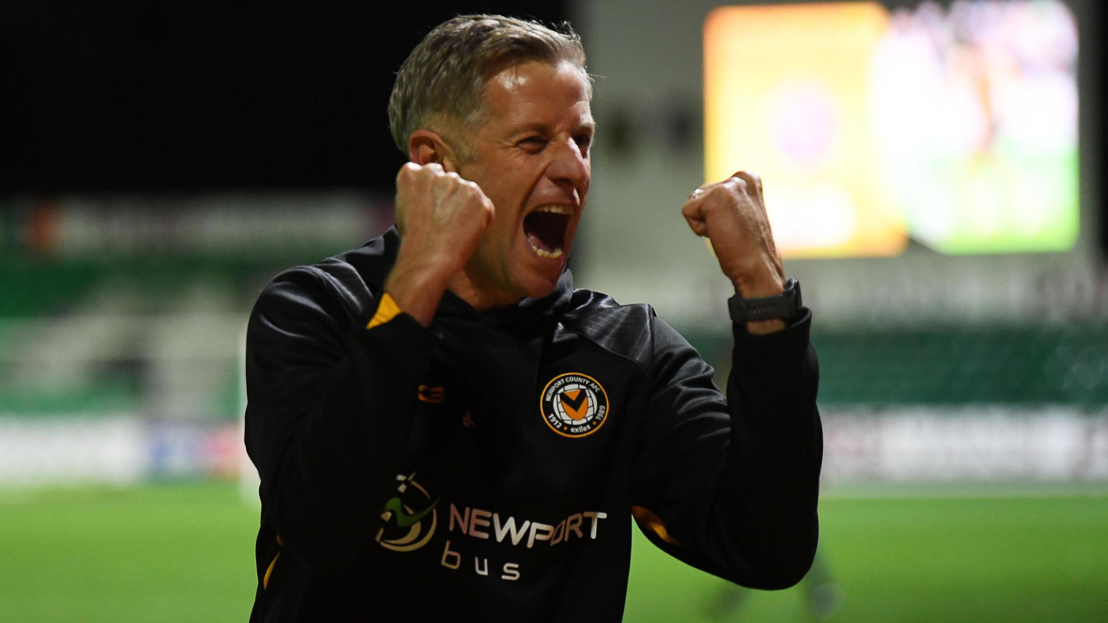 Dave Hughes in a Newport training kit shouts and clenches his first in celebration