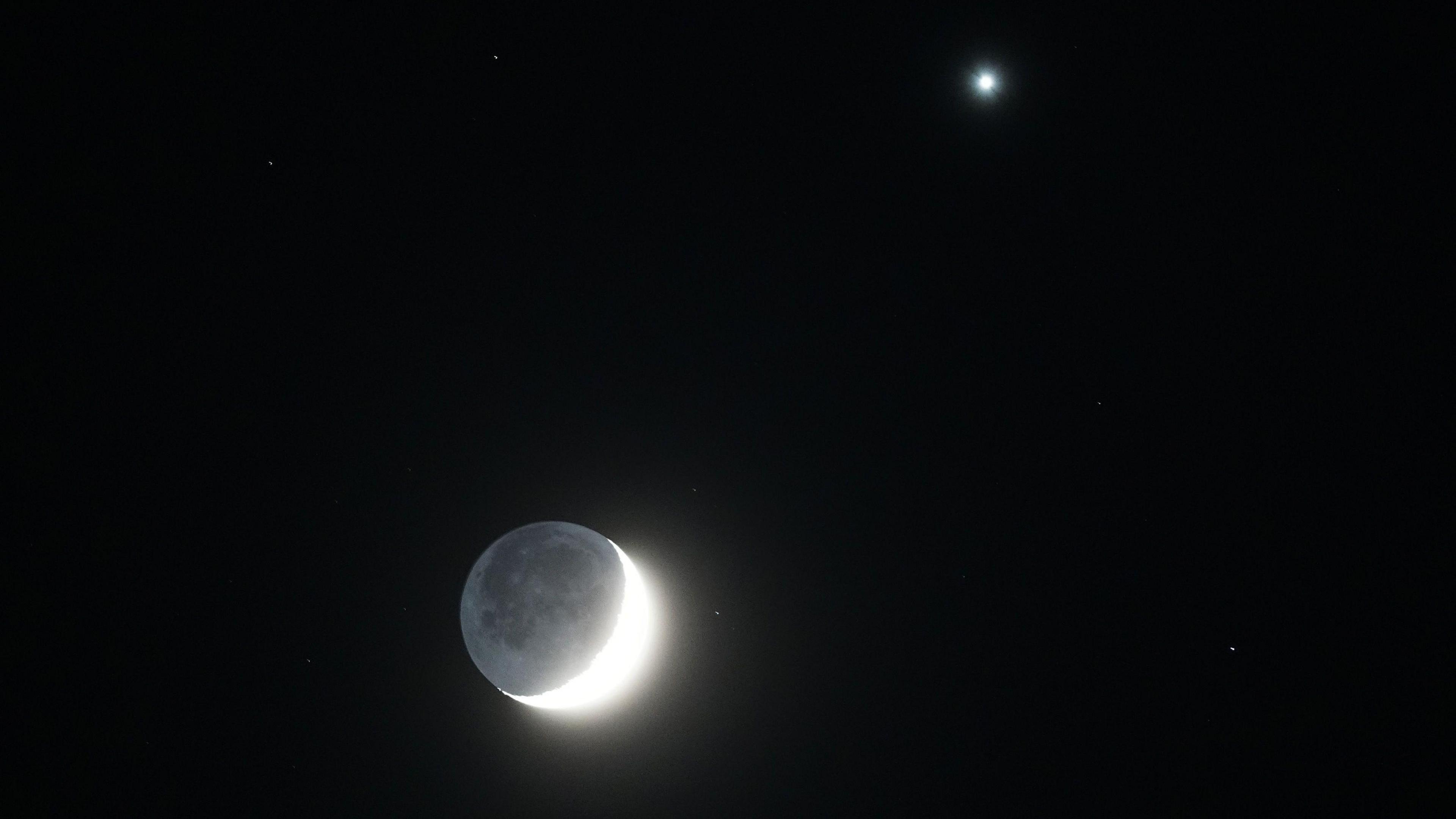 A crescent moon and the planet Venus together I the night sky