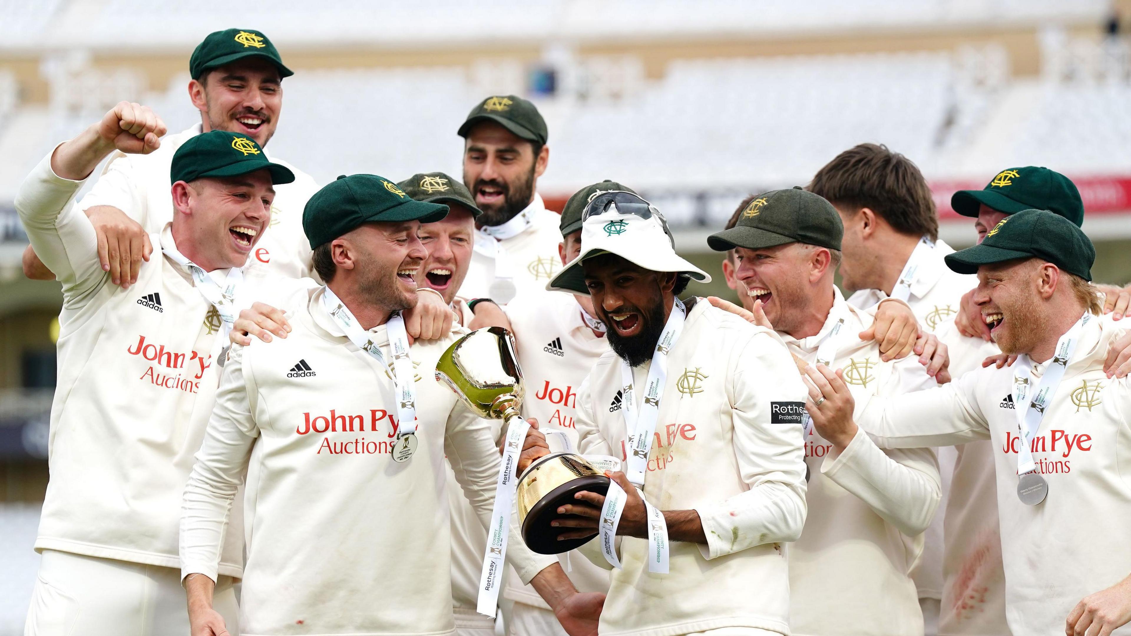 Haseeb Hameed holds the County Championship trophy surrounded by team-mates