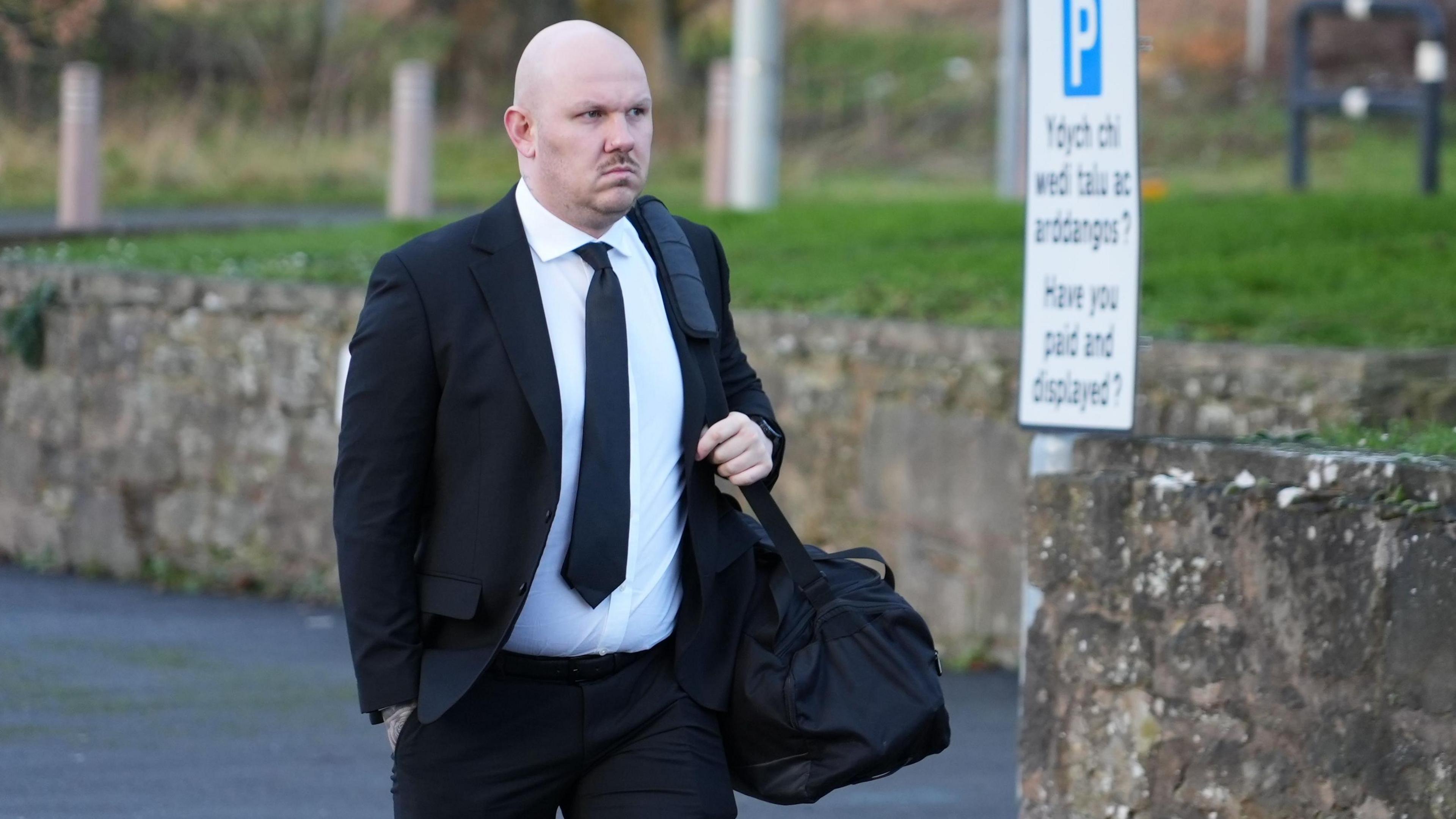 Miles Cross, mewn crys gwyn a siwt a thei du, yn cyrraedd y llys fore Mercher